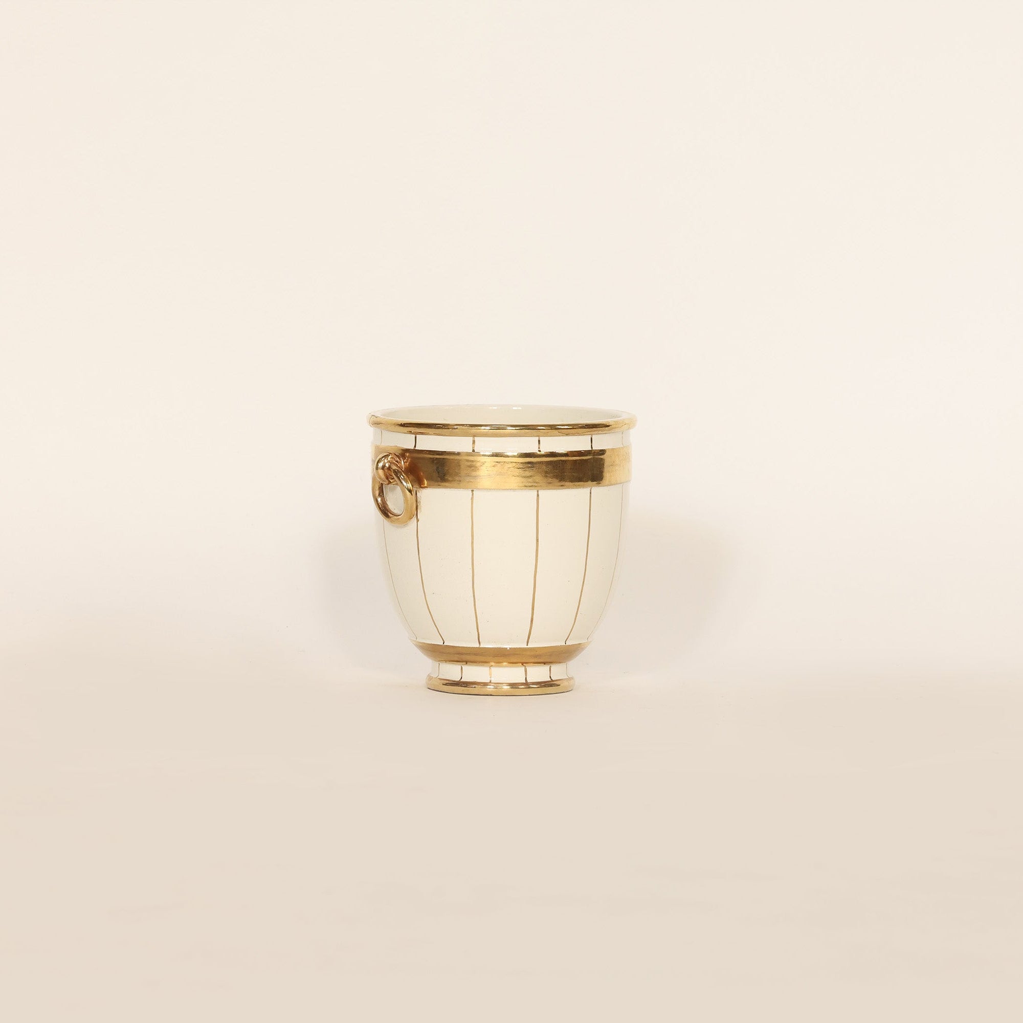 Decorative vase with gold accents on a beige background
