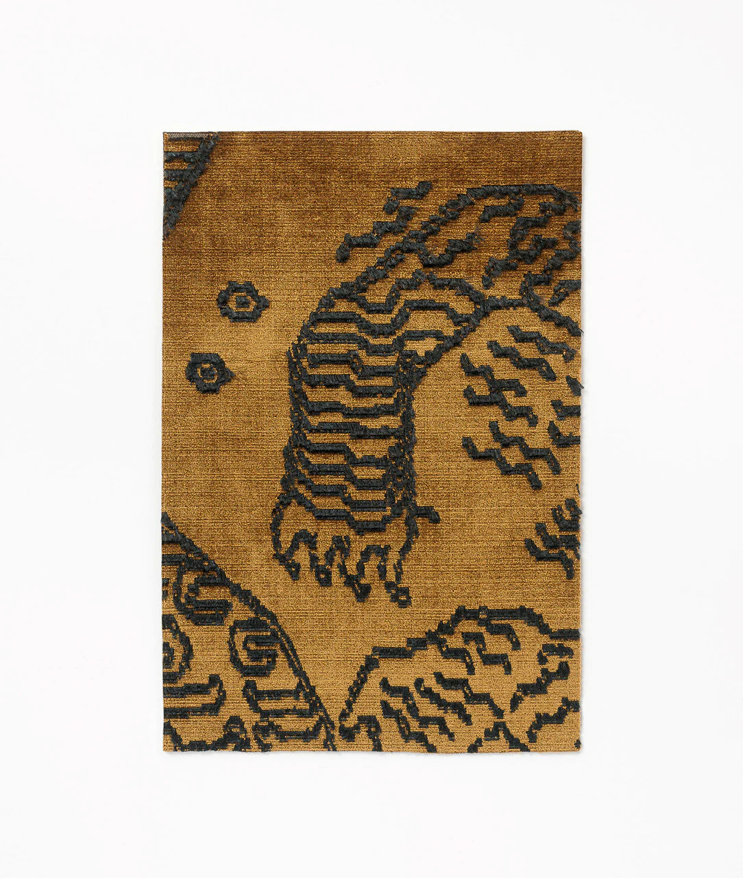 A rectangular rug with a golden-brown background and abstract black patterns pairs perfectly with the Forsyth Mushroom Pouf in Dedar 'Tiger Mountain' Jacquard Velvet, both set against a plain white surface.