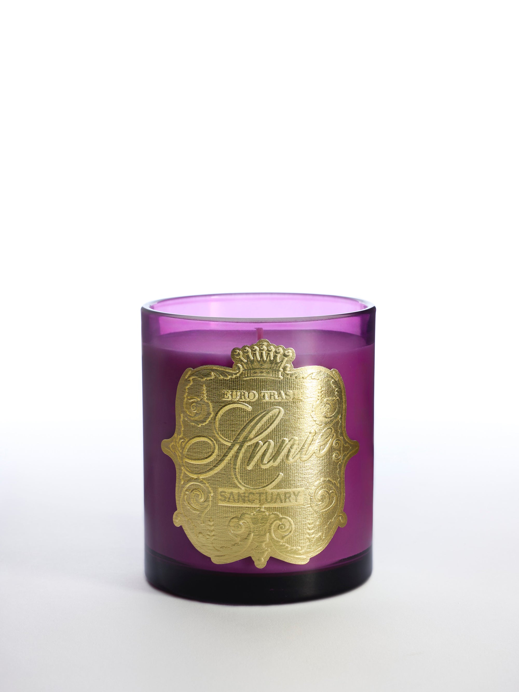 A purple glass candle holder with an ornate gold label reading "Sanctury" and decorative designs, this luxury home fragrance is displayed against a white background.