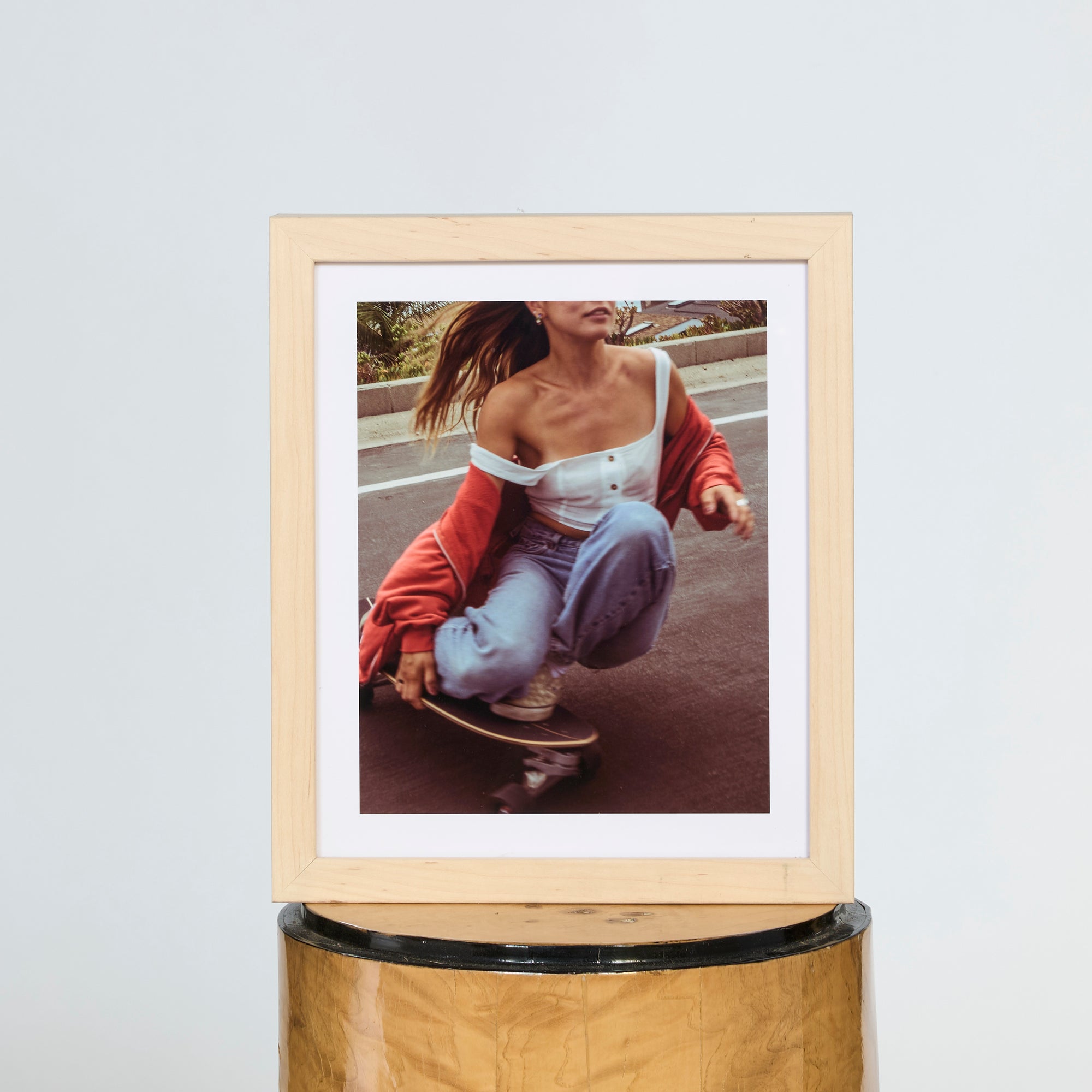 Framed photo of a person with a skateboard on a white wall