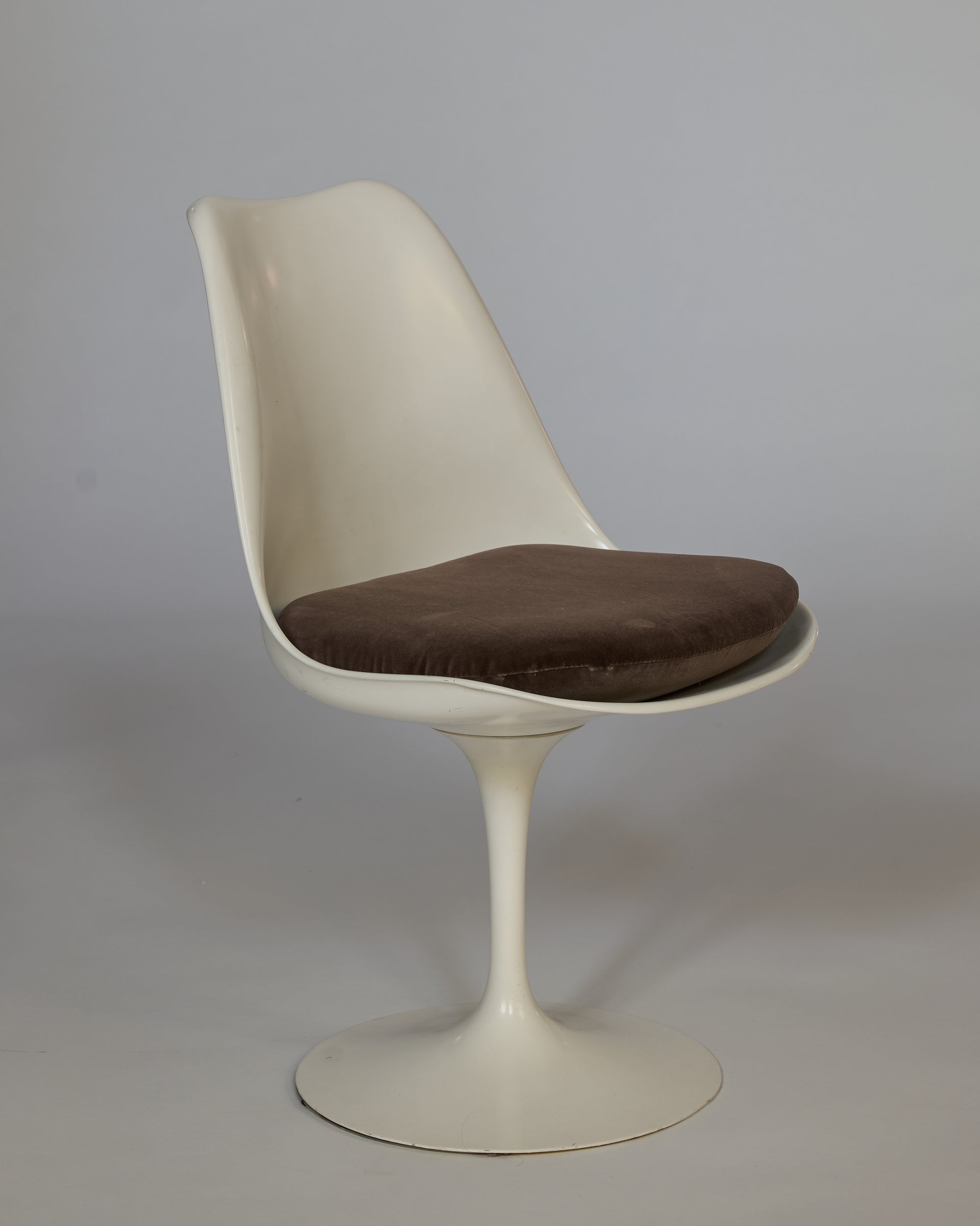 The Vintage Mid-Century Modern Tulip Chair with Cushioned Seat features a white curved backrest, single pedestal base, and brown seat cushion, shown against a plain gray background.