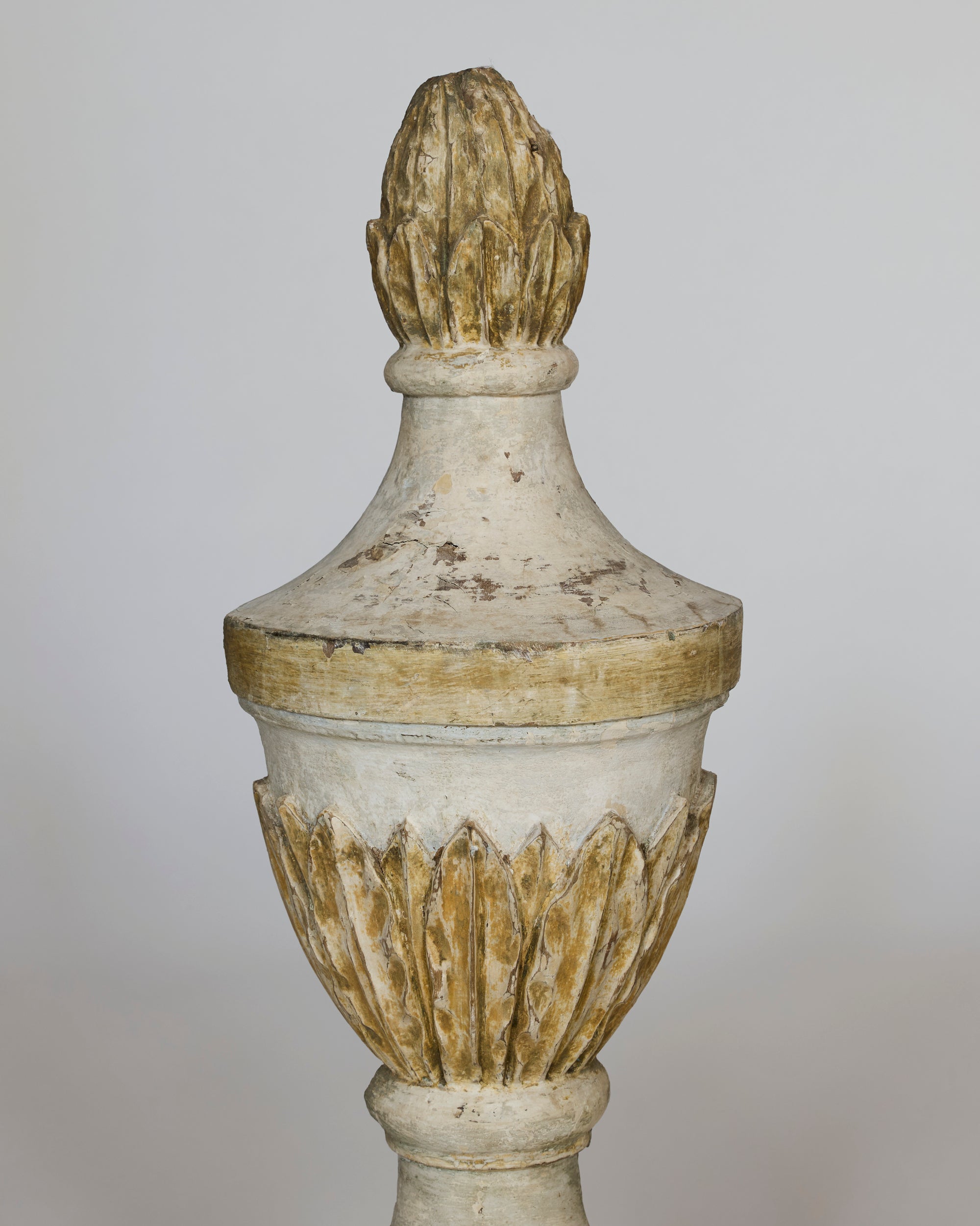This pair of antique carved wooden finials features a weathered white and gold finish, leaf motifs, and pointed tops—exquisite architectural ornaments perfect for adding classic style to any décor.