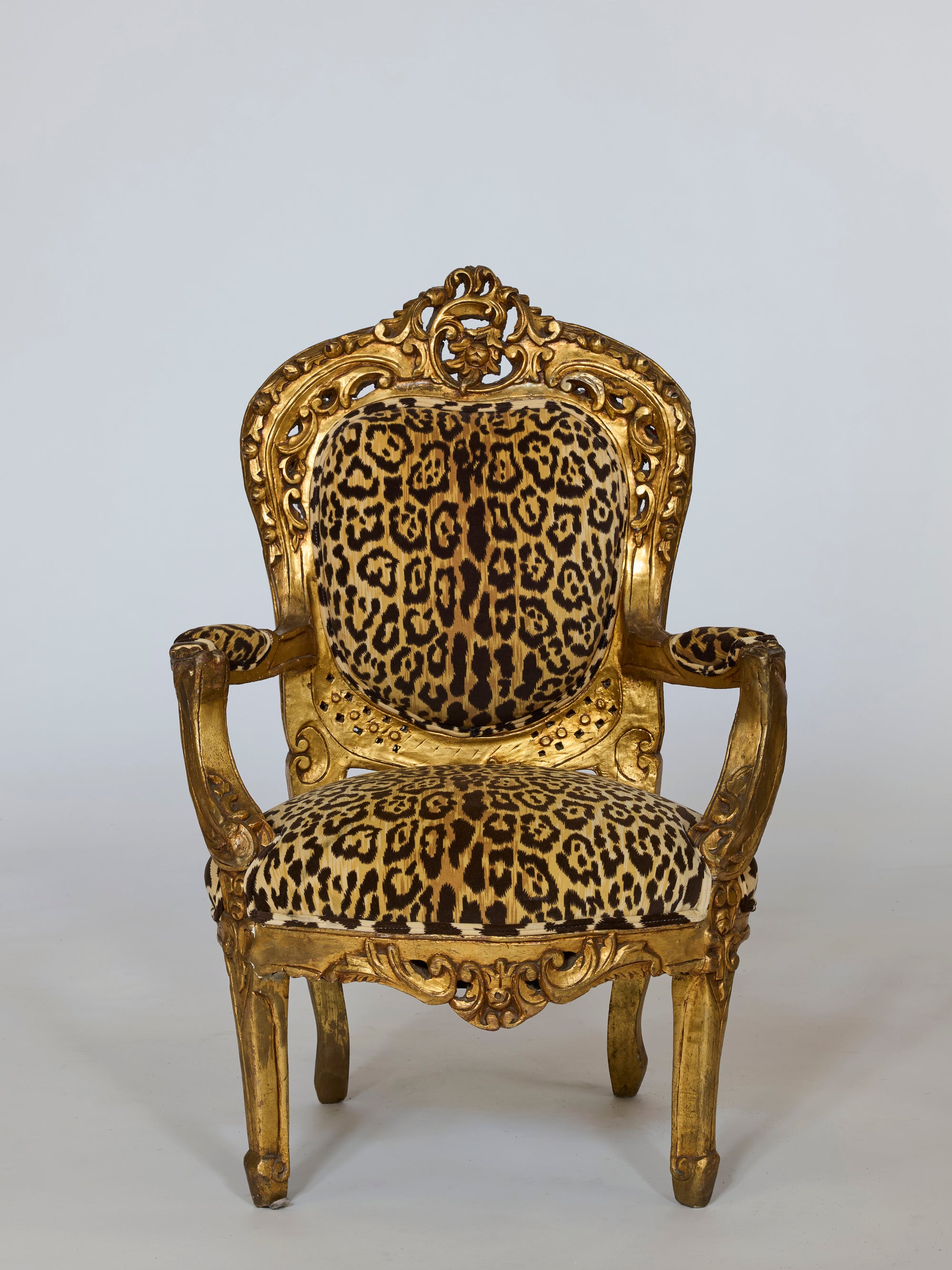 Pair of Leopard Upholstered Gilt Armchair with Carved Baroque Frame, featuring ornate gold detailing and bold leopard fabric on the seat, backrest, and armrests, displayed against a plain white background.