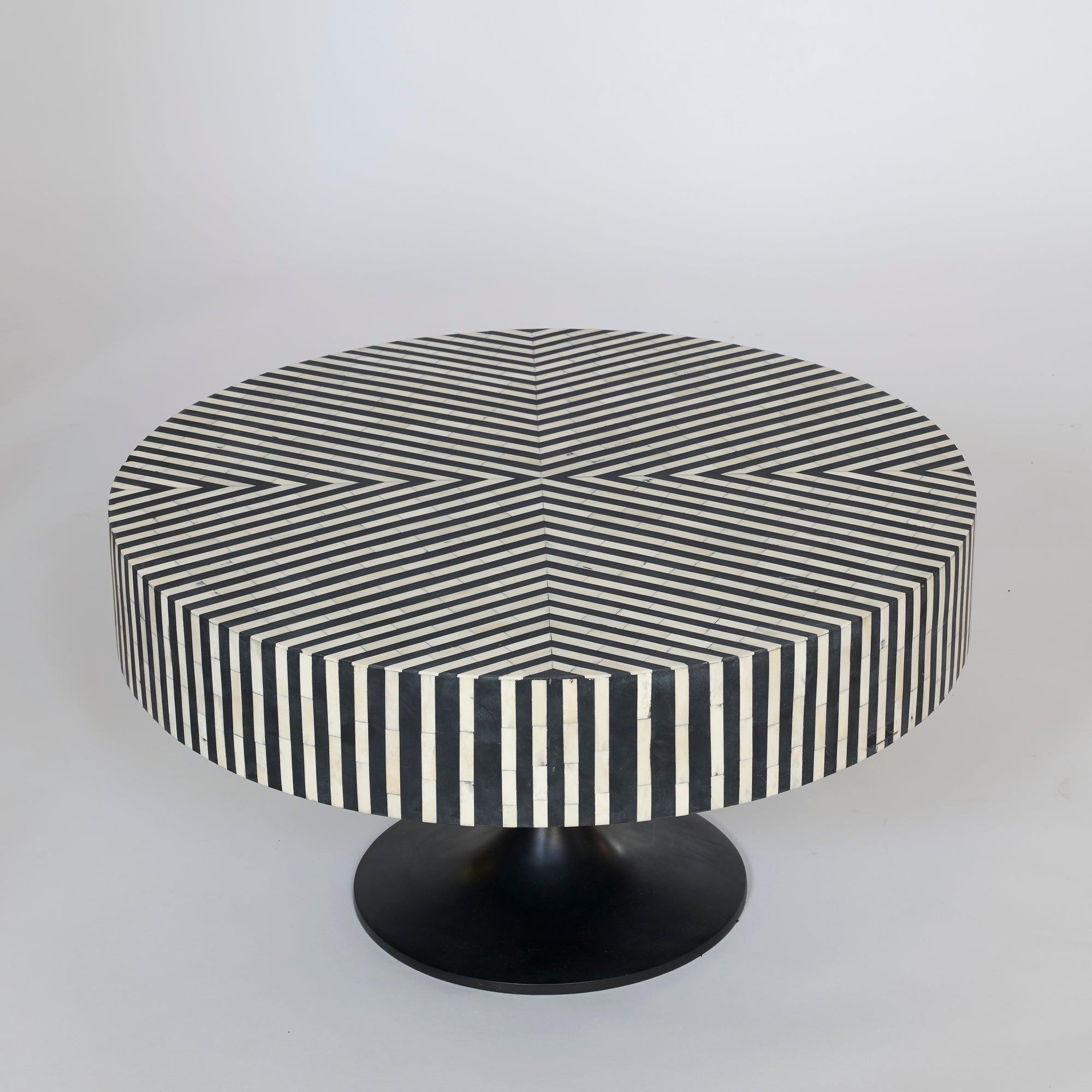 The Black and White Striped Round Coffee Table showcases a bold striped pattern on its top and sides, creating a striking optical illusion with its modern geometric pedestal design.