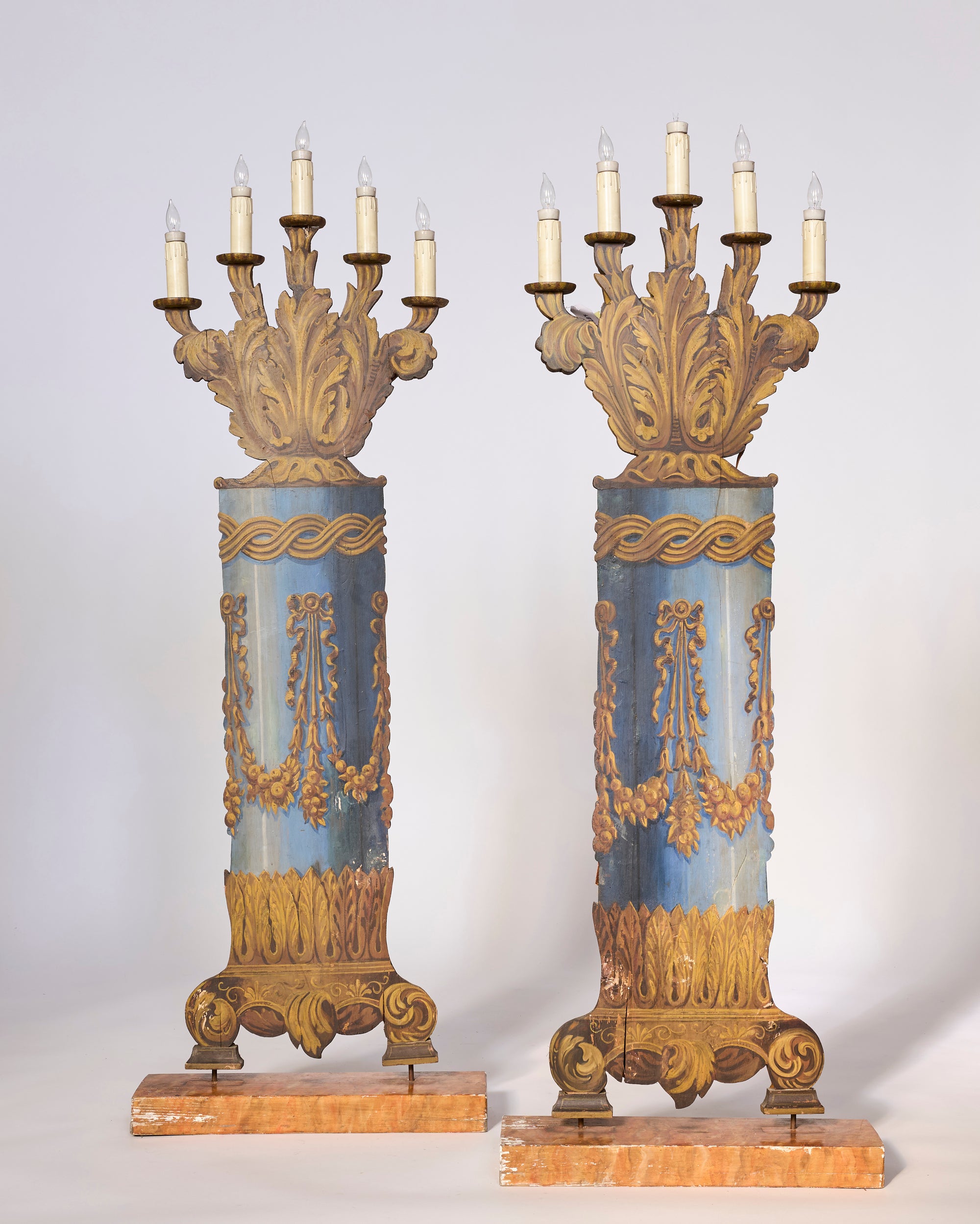 Pair of Antique Opera House Stage Candelabra featuring ornate column shapes, blue and gold details, carved garlands and leaf motifs. Each candelabrum has seven candle-like lights on top and a decorative base.