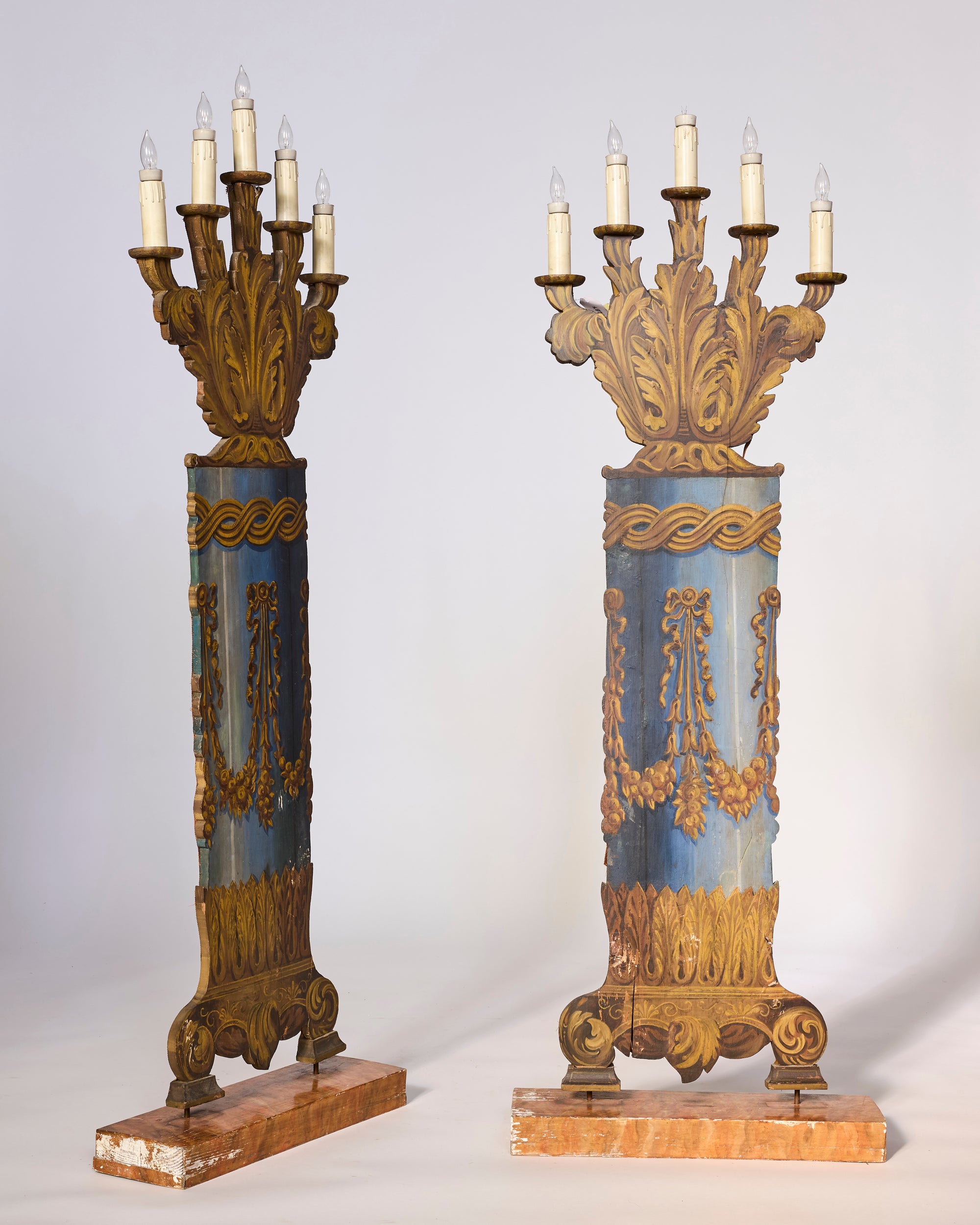 The Pair of Antique Opera House Stage Candelabra features ornate blue and gold designs, multiple electric candle bulbs, and rectangular marble bases, evoking the grandeur of neoclassical stage lighting.