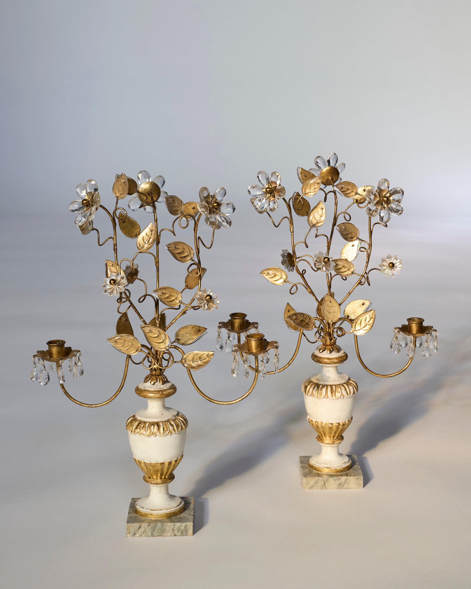 Pair of Floral Gilt Candelabra with Crystal Drops on Marble Bases displayed side by side, each featuring European-inspired floral design and three curved branch-shaped candle holders.