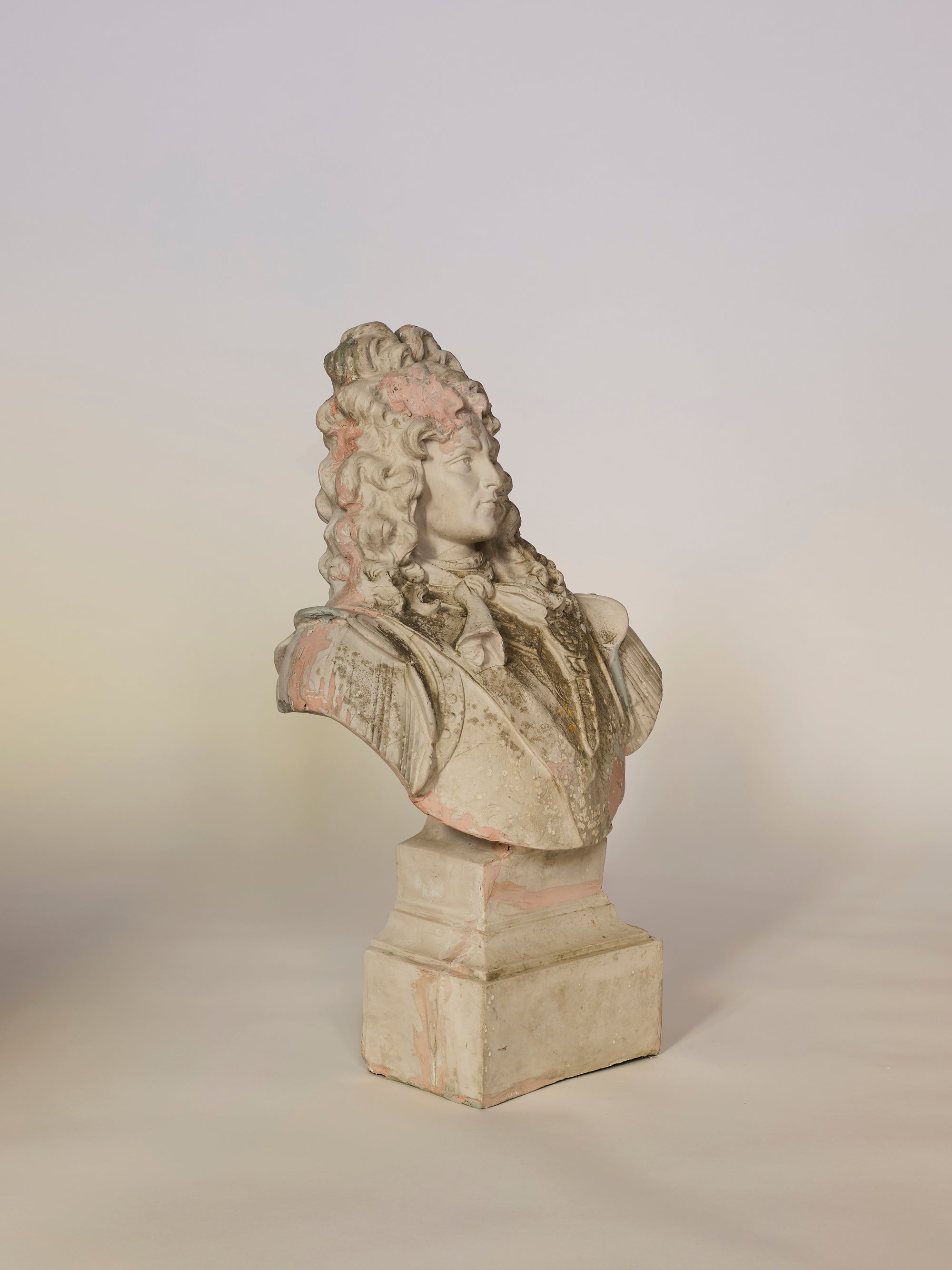 Bust sculpture of a person with powdered wig on a plain background