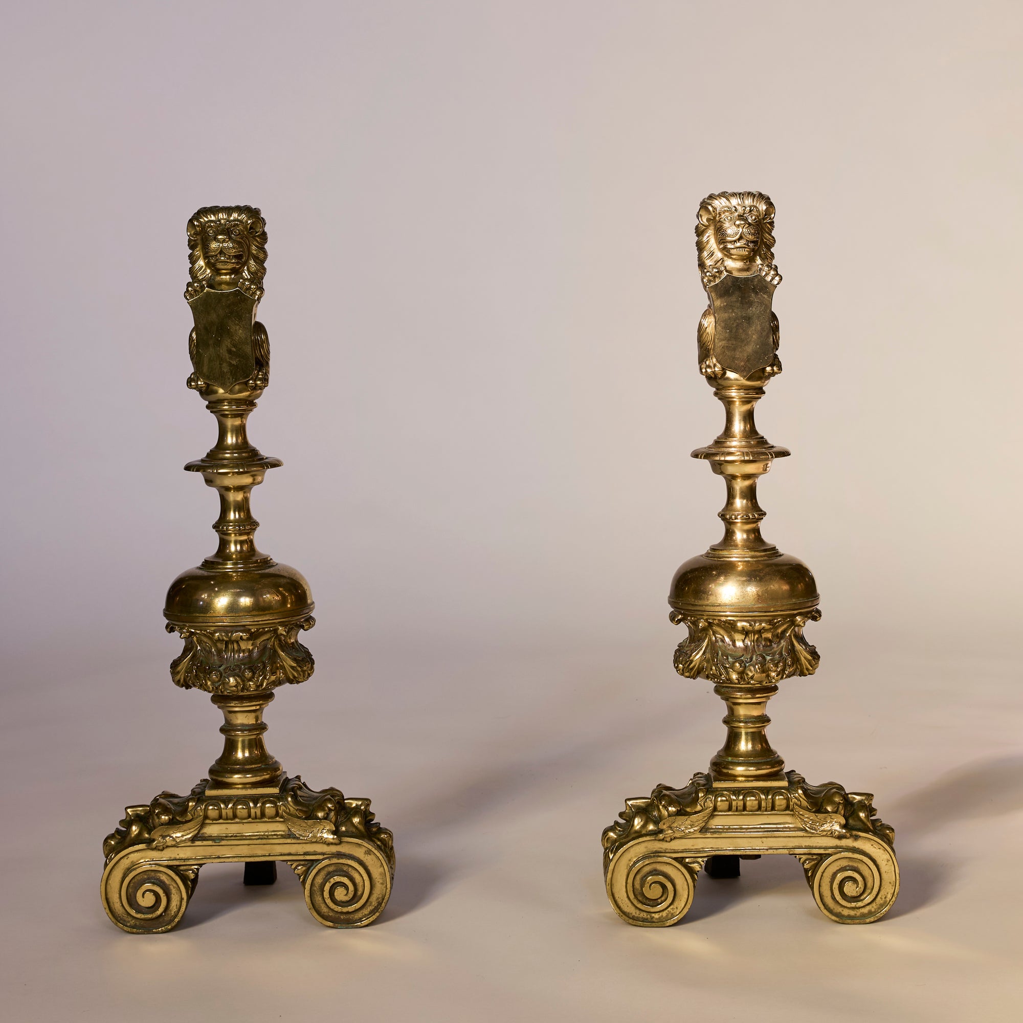 Pair of ornate brass candlesticks on a neutral background