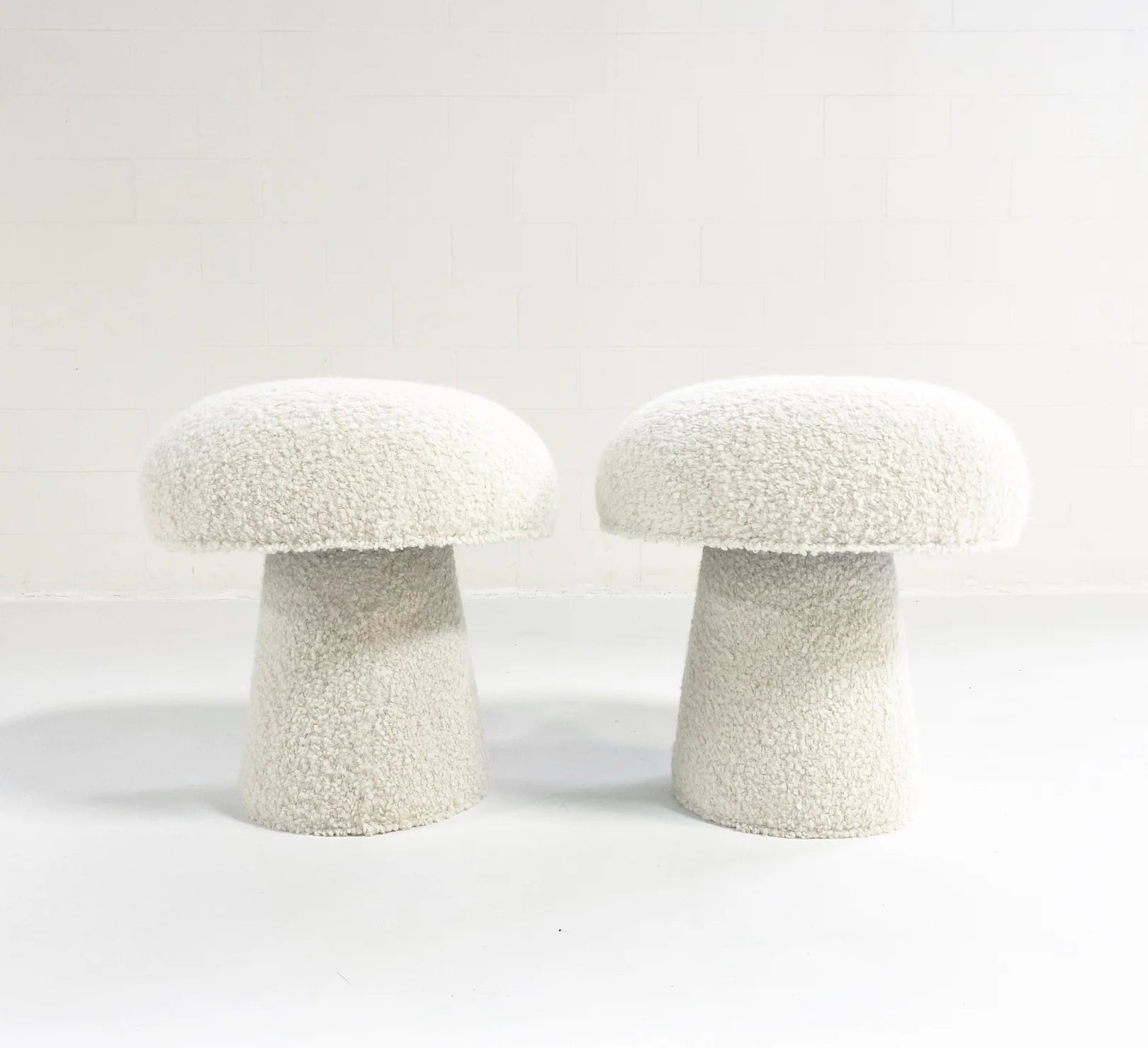 Two white Forsyth Mushroom Pouf stools in soft boucle upholstery stand side by side against a white background, creating a cozy, decorative pouf-inspired look.