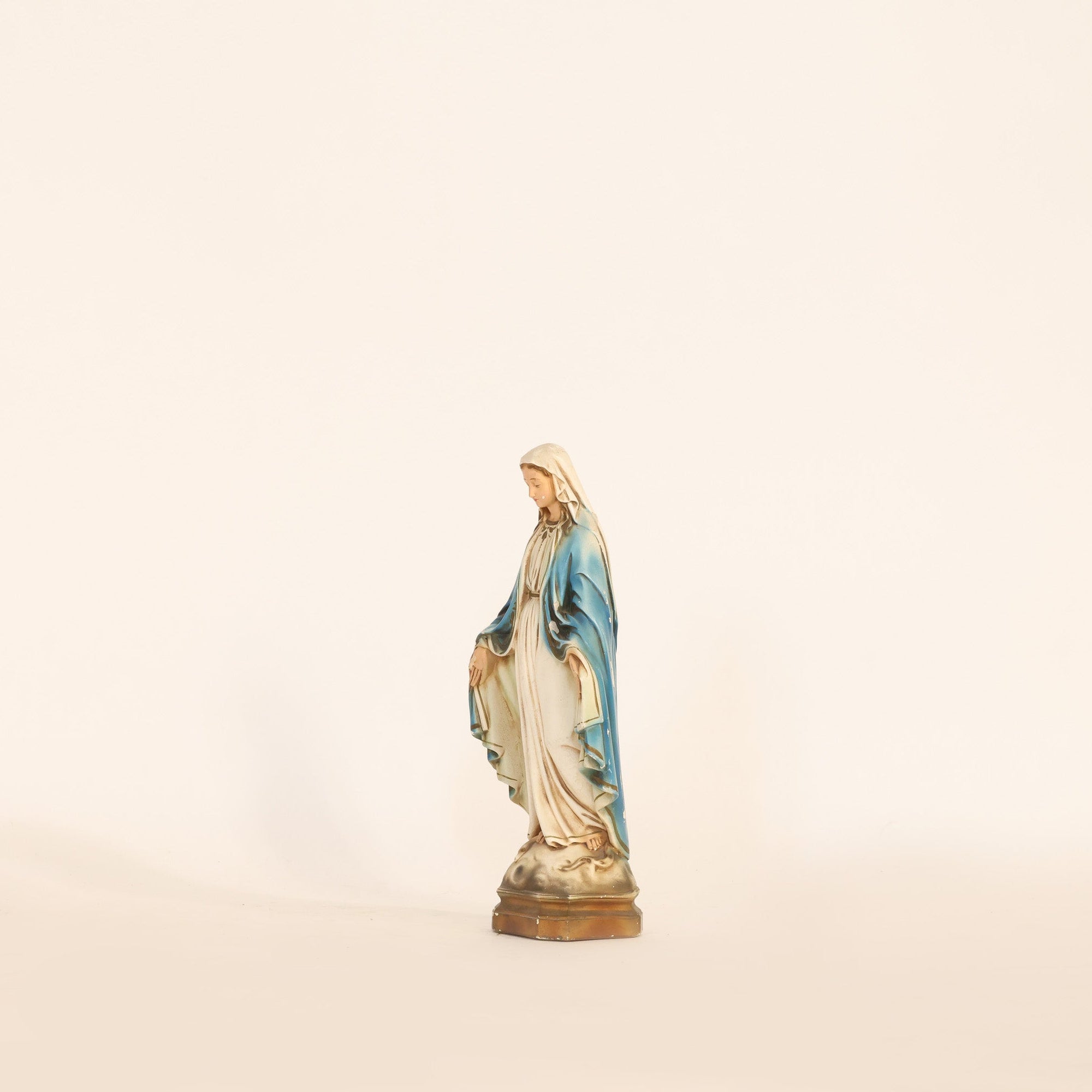 Statue of a religious figure on a beige background
