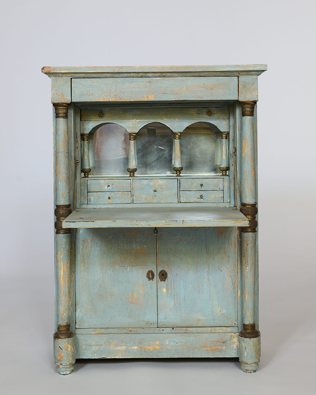 A pair of distressed painted European cabinets with turned columns, featuring a blue-green patina inspired by continental styles—ideal for provincial interiors.
