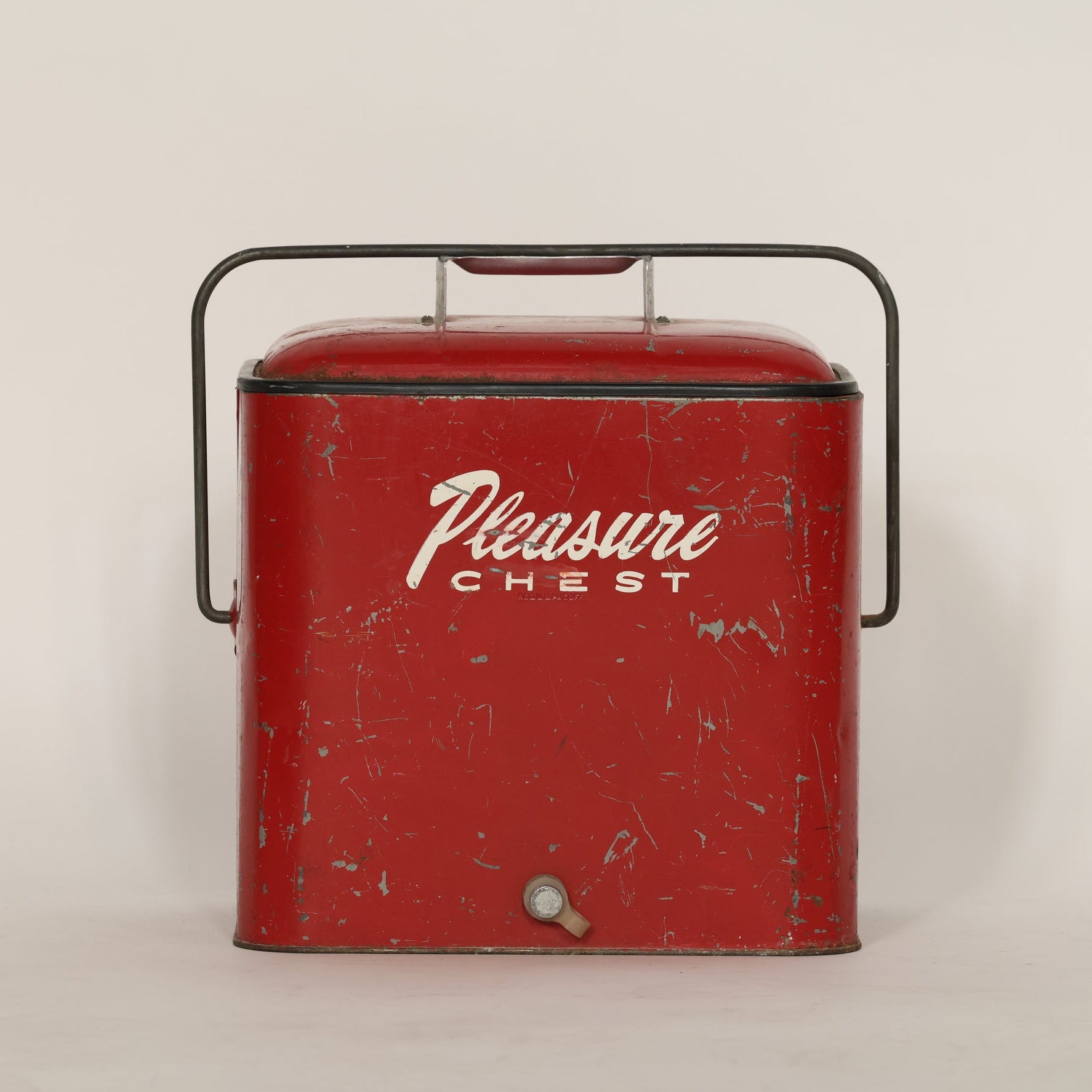 Vintage red 'Pleasure Chest' cooler on a beige background