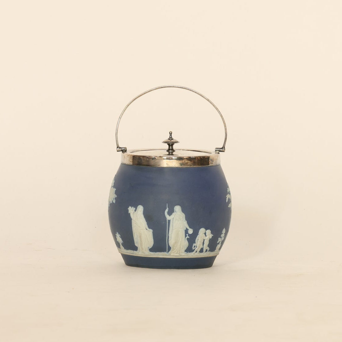 Decorative blue jar with white relief designs on a beige background