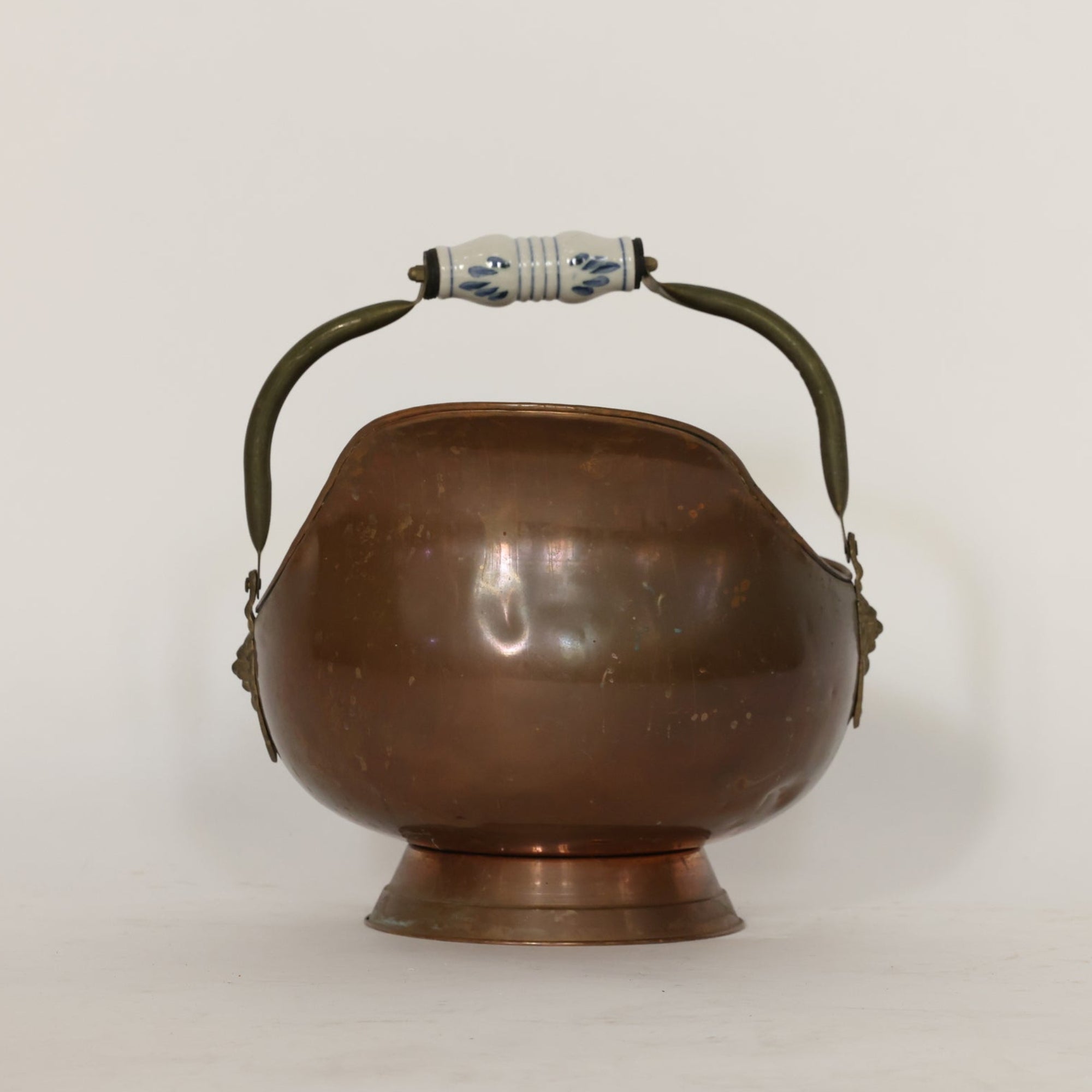 Bronze scuttle with handles and lion emblem on a white background