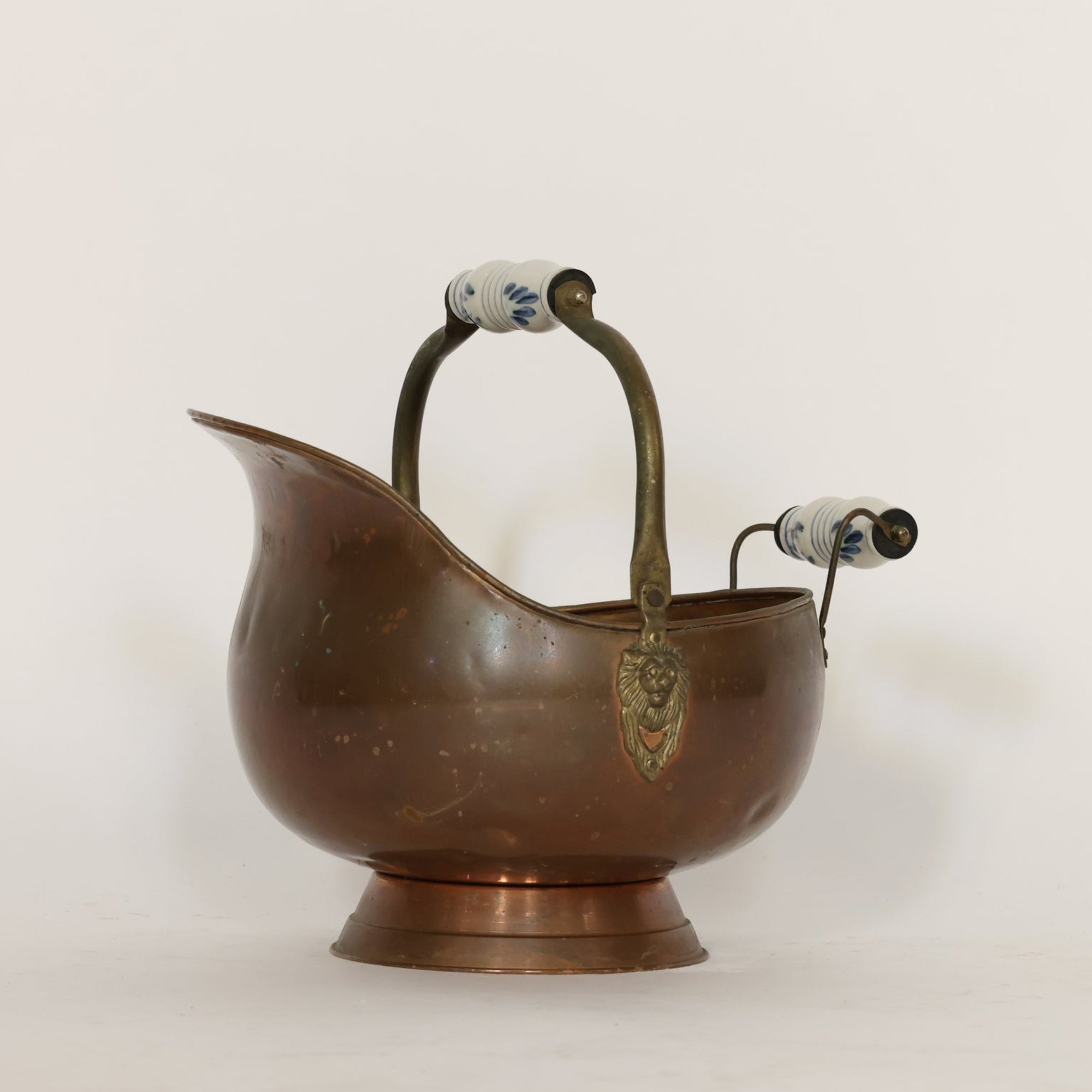 Bronze scuttle with handles and lion emblem on a white background