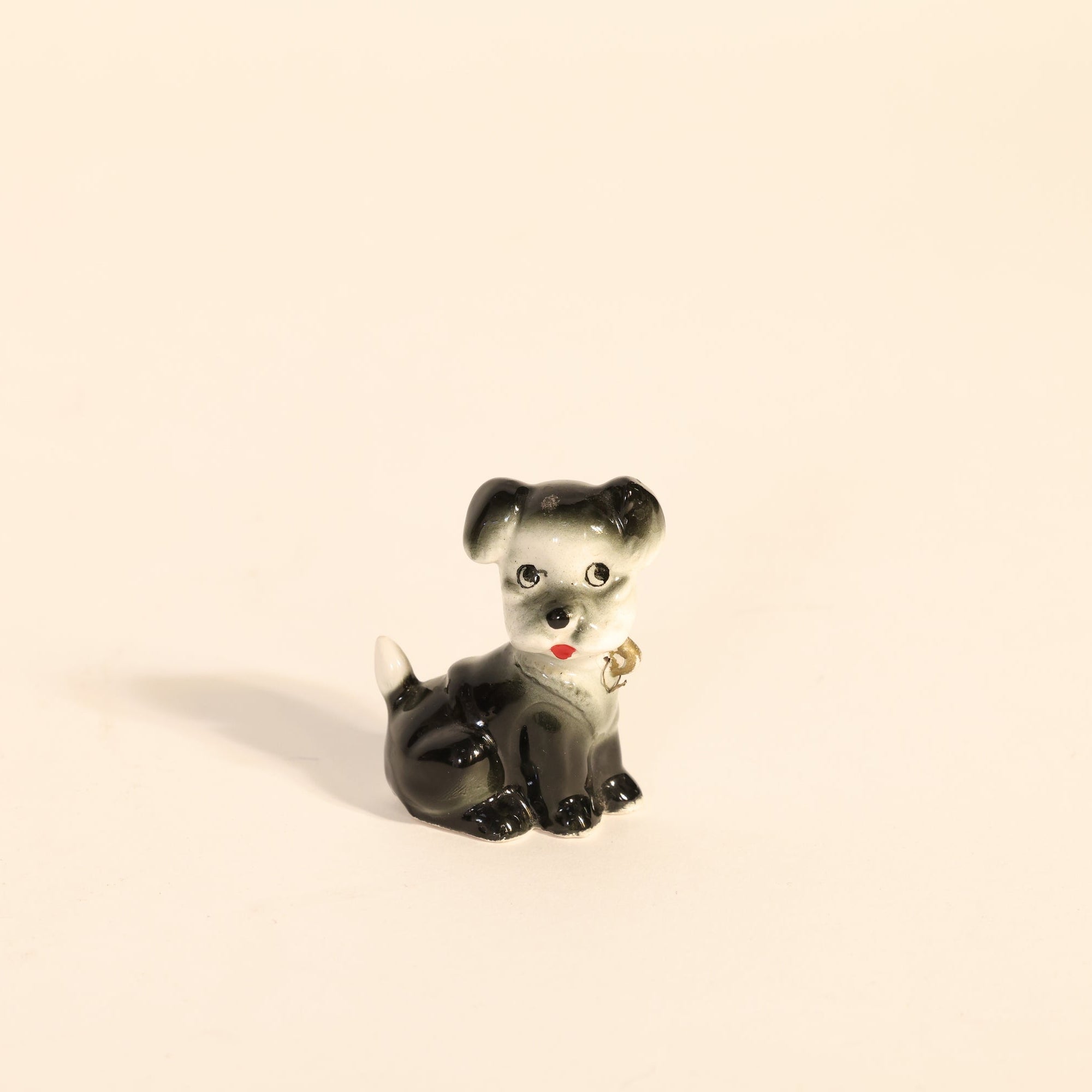 Small black and white dog figurine on a beige background