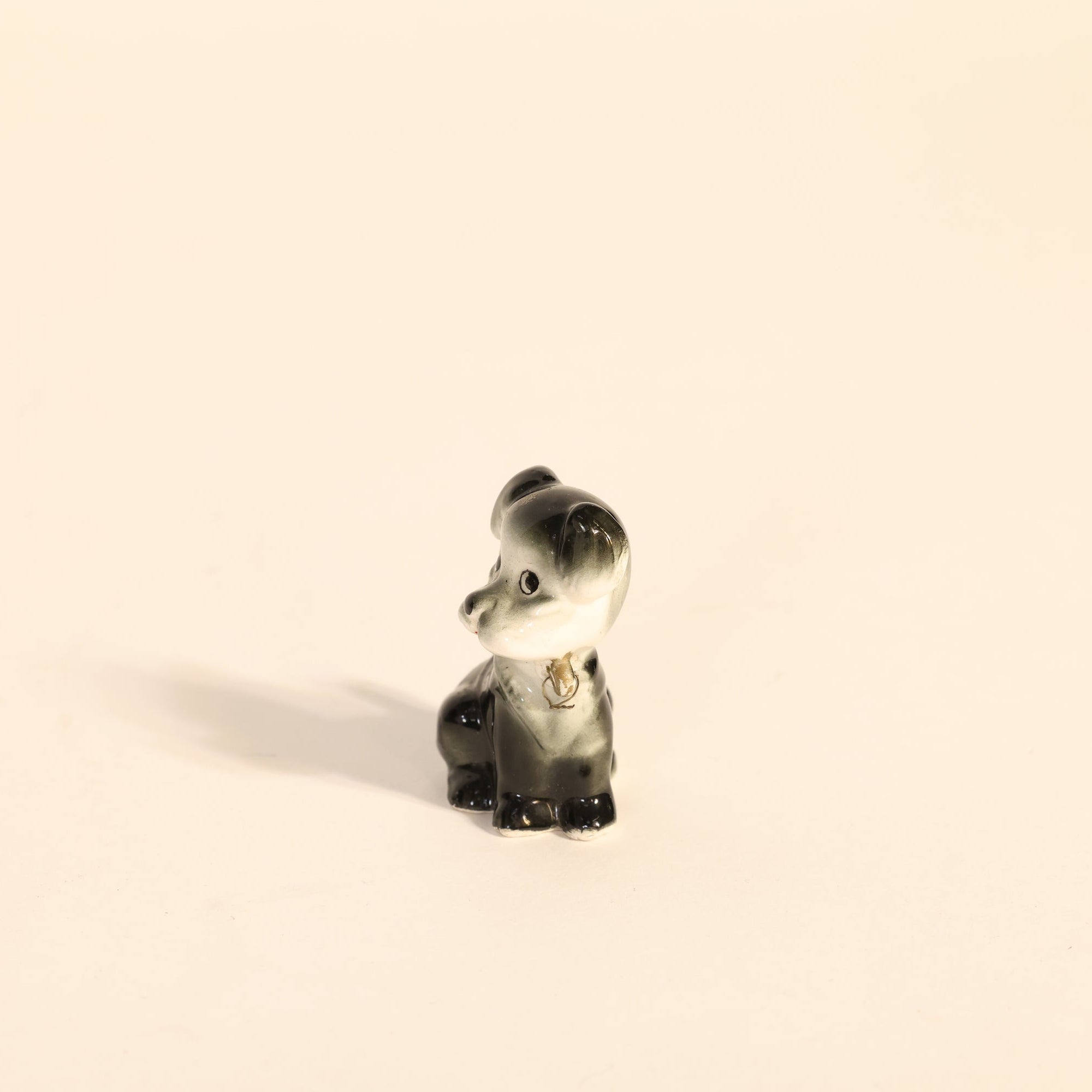 Small figurine of a dog on a beige background