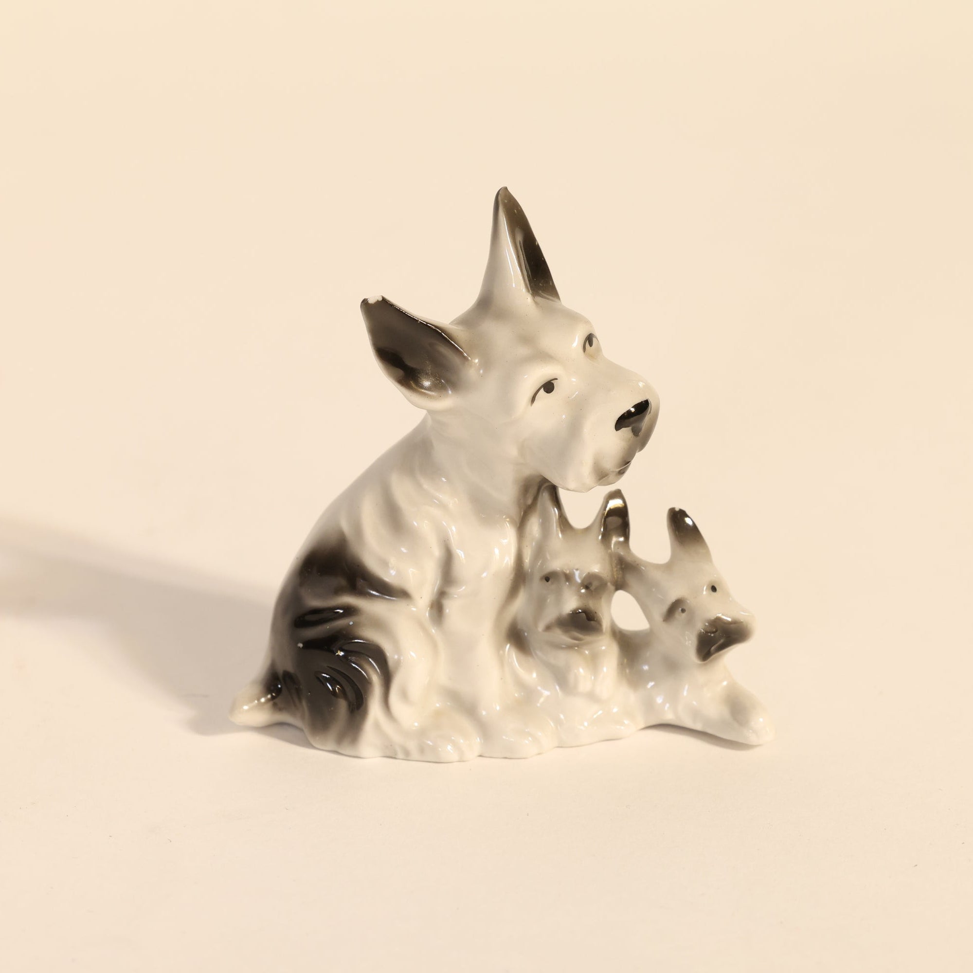 Ceramic dog figurine with two puppies on a beige background