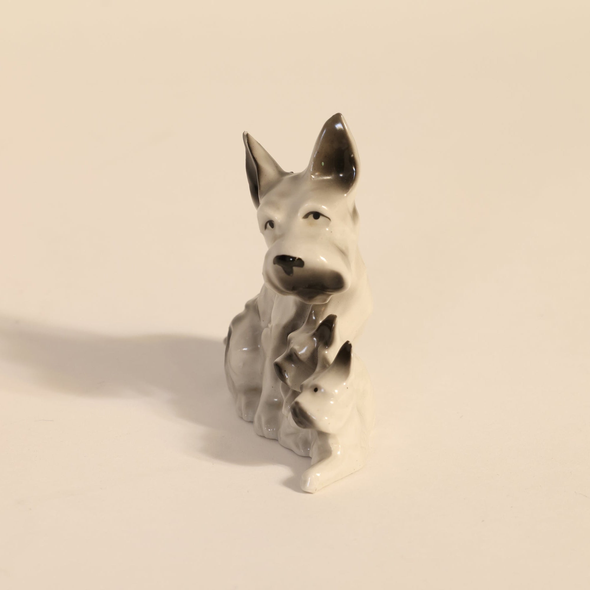 Small ceramic dog figurine on a beige background
