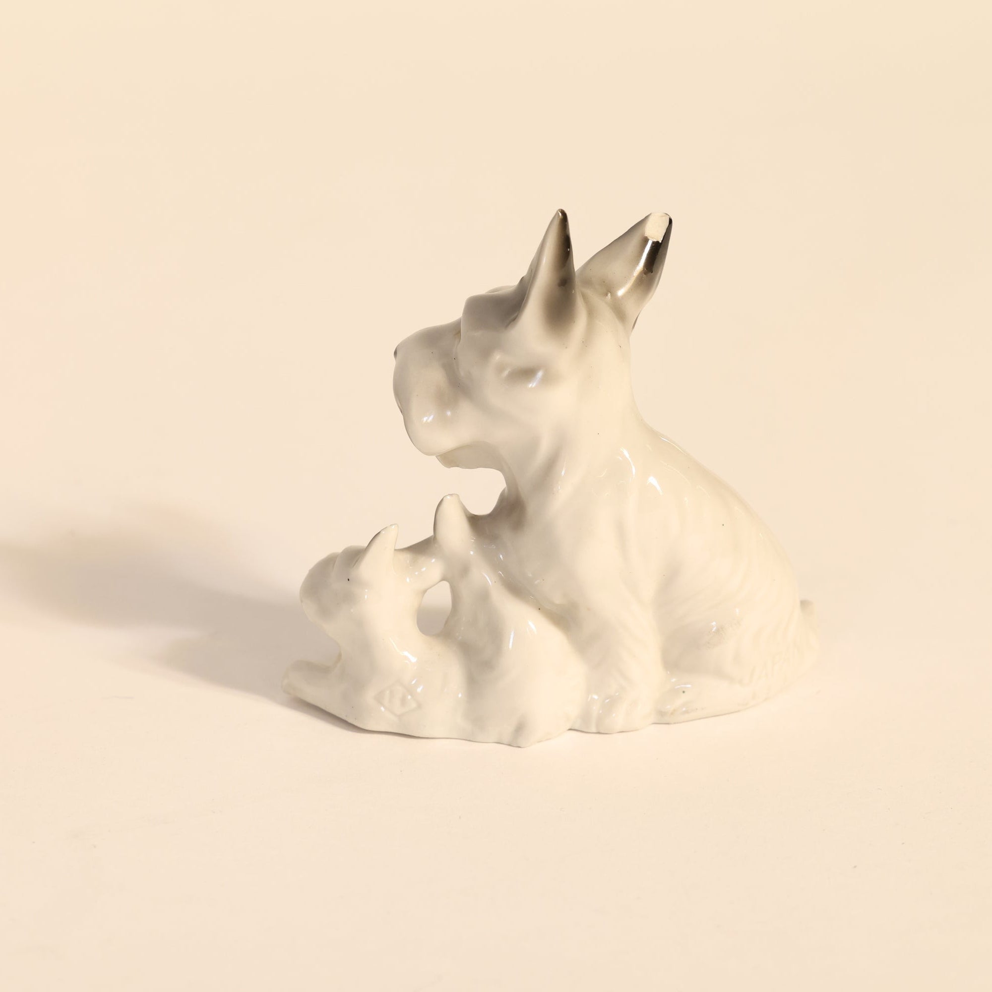 White ceramic dog figurine on a beige background