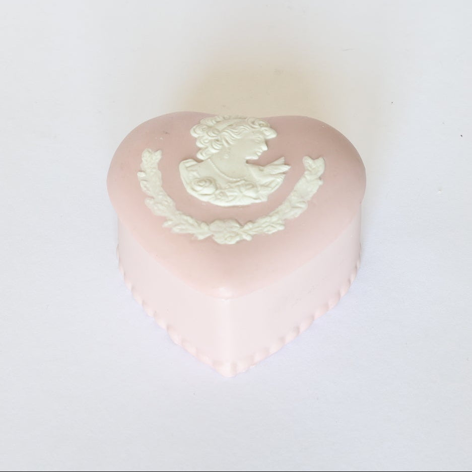 The Euro Trash Annie Vintage Jasperware Style Heart Trinket Box is heart-shaped in pale pink with a white cameo profile and floral relief, shown on a plain white background.