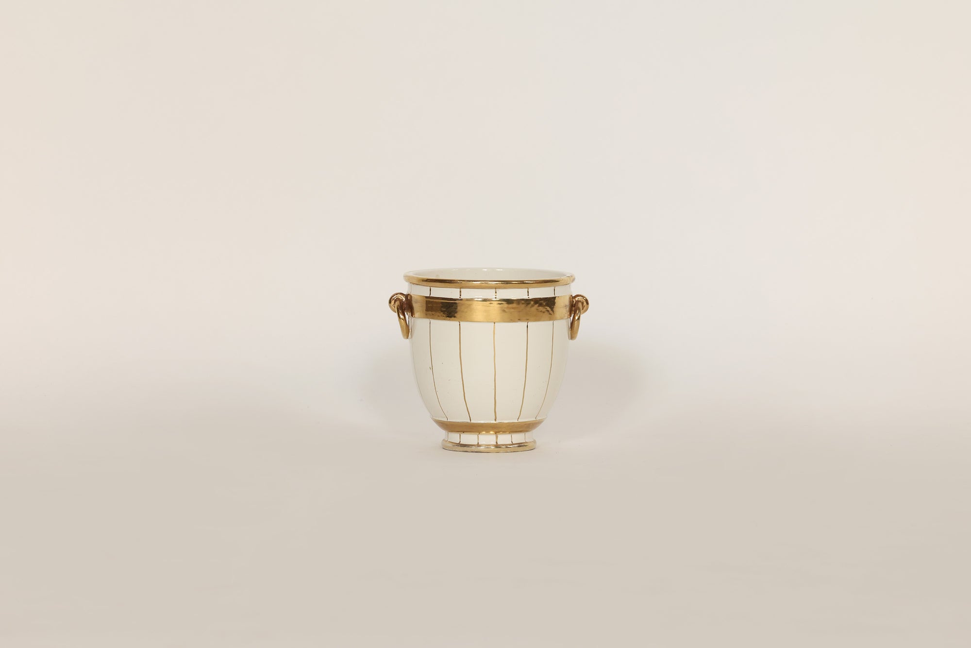 Decorative vase with gold accents on a beige background