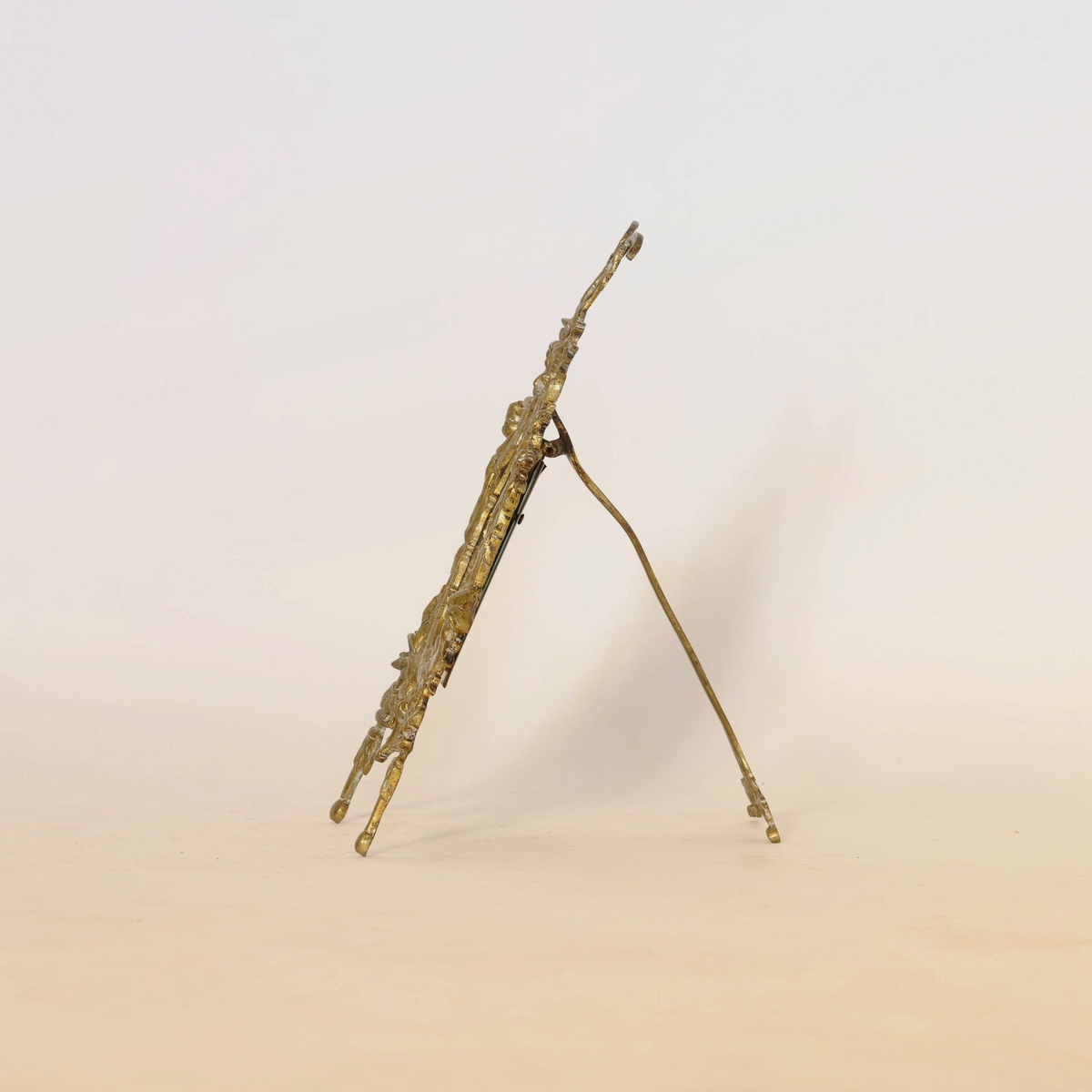 A side view of the Euro Trash Antique Gilt Bronze Rococo Easel Mirror standing upright on its support, set against a plain light background.
