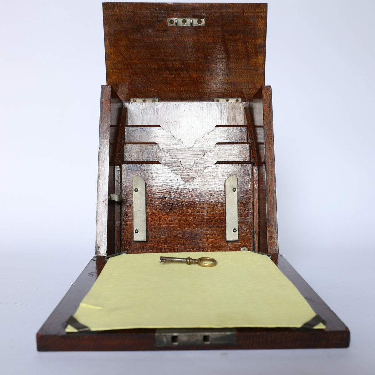 The Euro Trash Antique Inlaid Wooden Document Box has a hinged lid, metal brackets, and interior slots. A metal key lies on yellow paper inside this decorative storage box, all set against a plain white background.