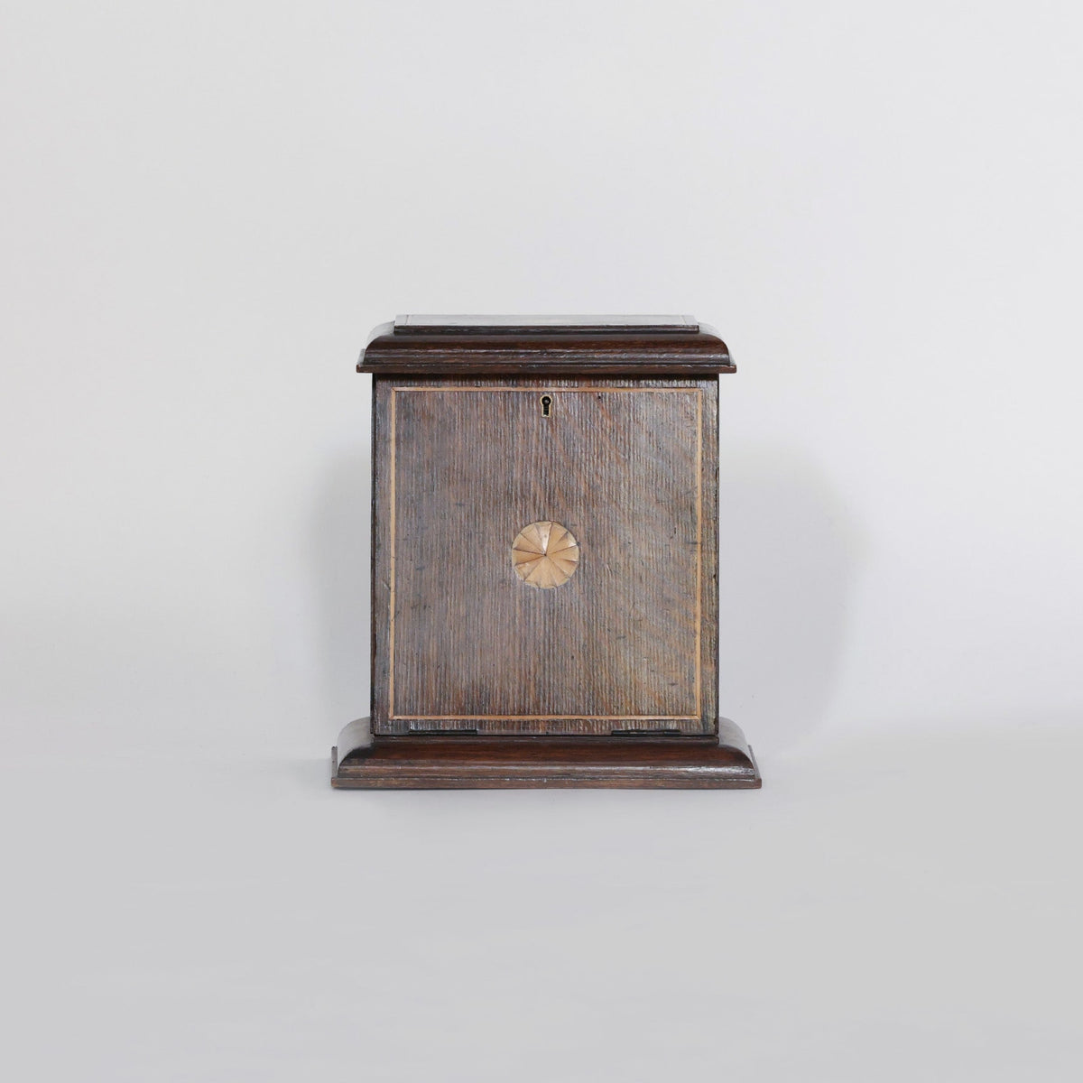 The Euro Trash Antique Inlaid Wooden Document Box is a square, dark wooden piece featuring a decorative circular inlay on the front and a small keyhole above it, displayed against a plain light background.