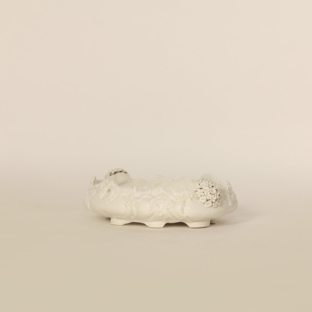 Decorative white ceramic planter on a beige background