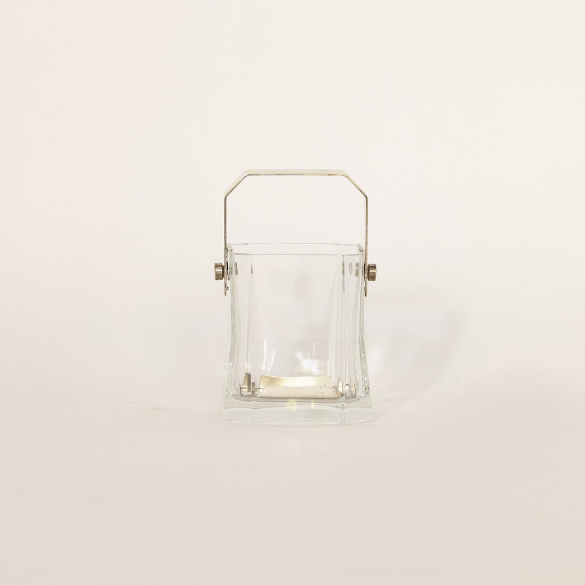 Vintage vessel composed of crystal and brass on beige background 
