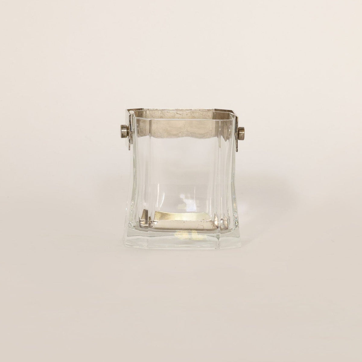 Vintage vessel composed of crystal and brass on beige background 