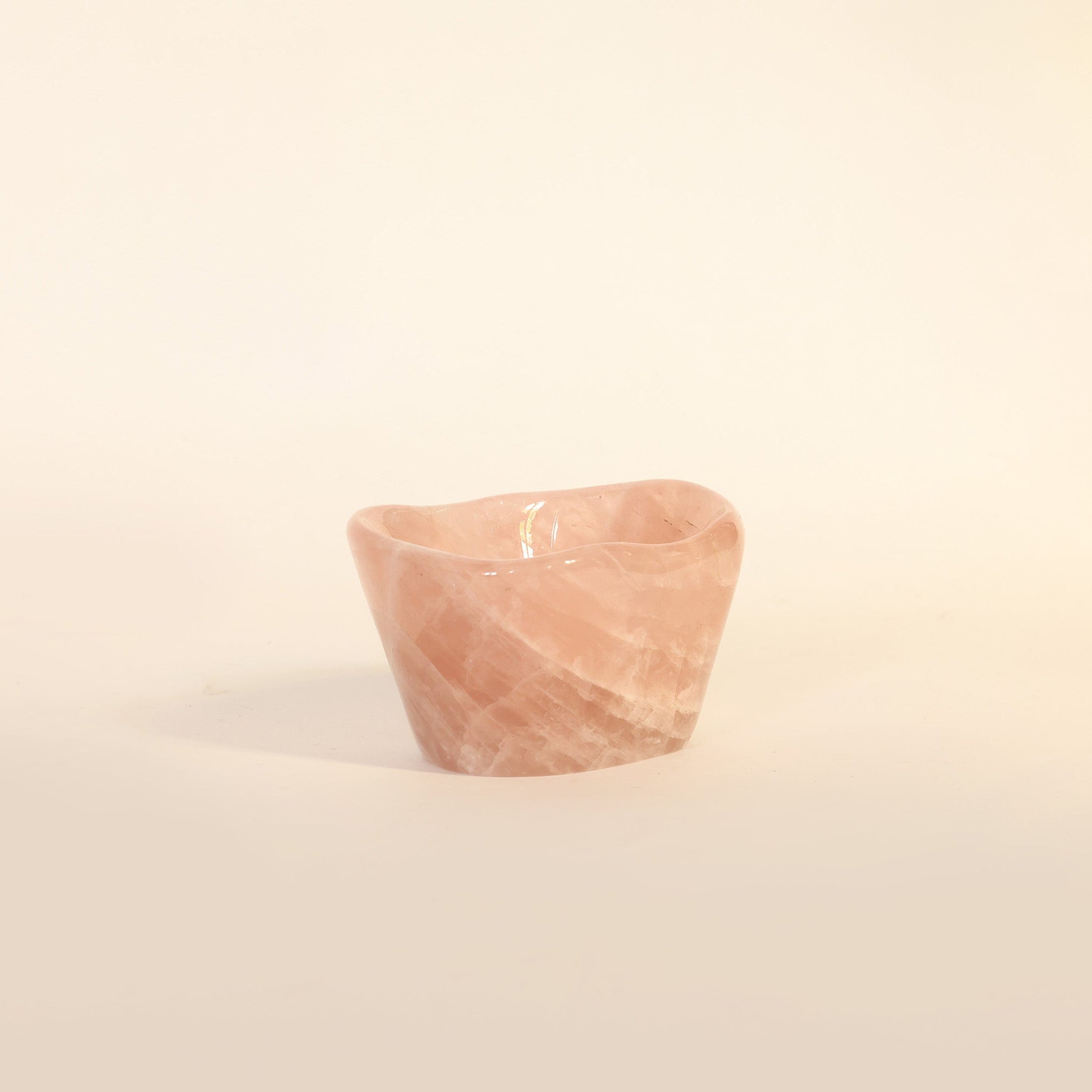 Small pink marble bowl on a beige background