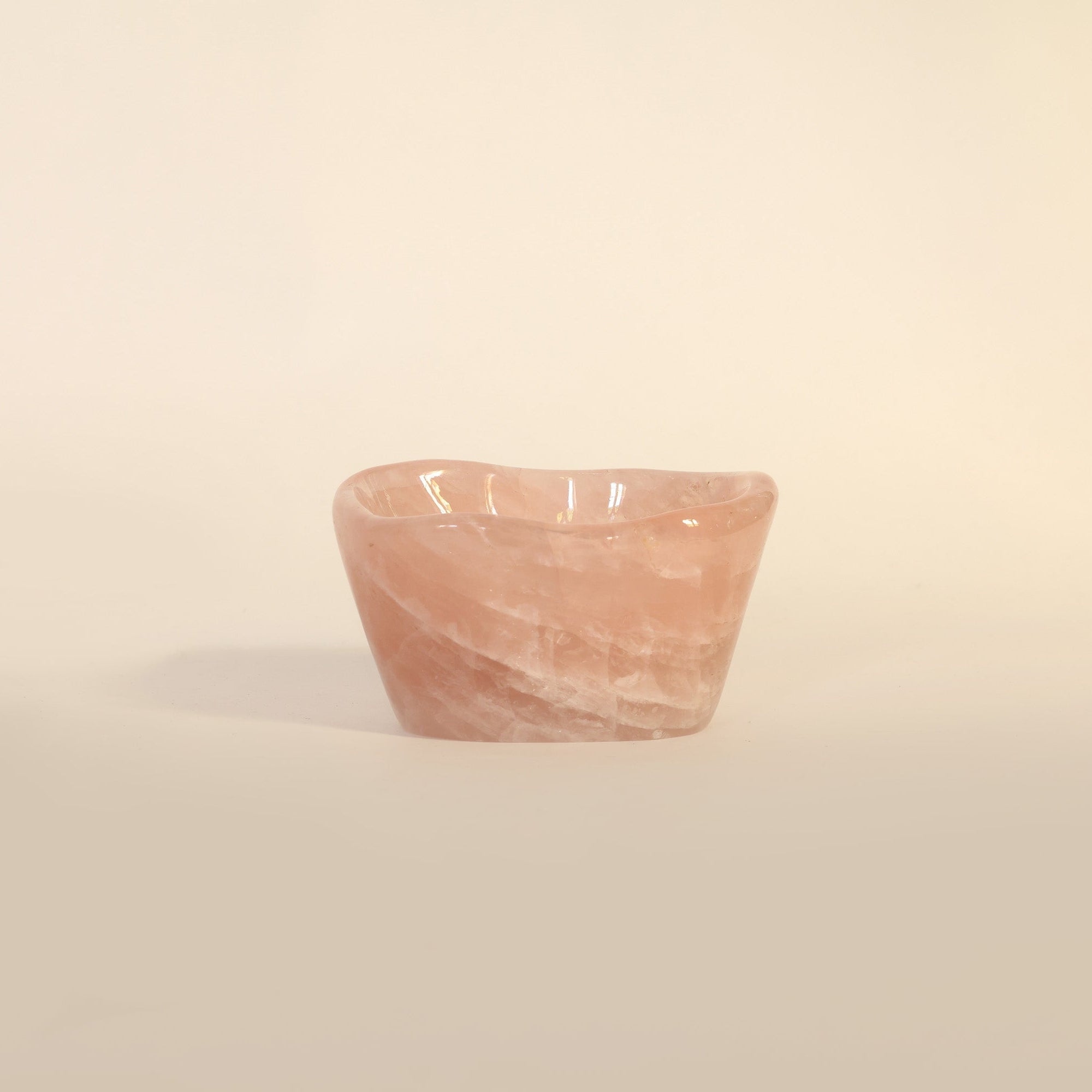 Small pink stone bowl on a beige background