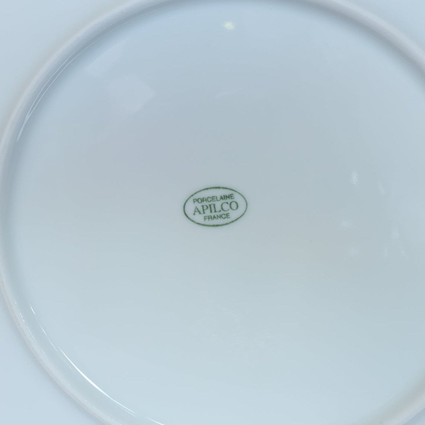 A close-up of the underside of a Vintage White Ceramic Shell Plate from Euro Trash, perfect for collectors of vintage ceramic plates.