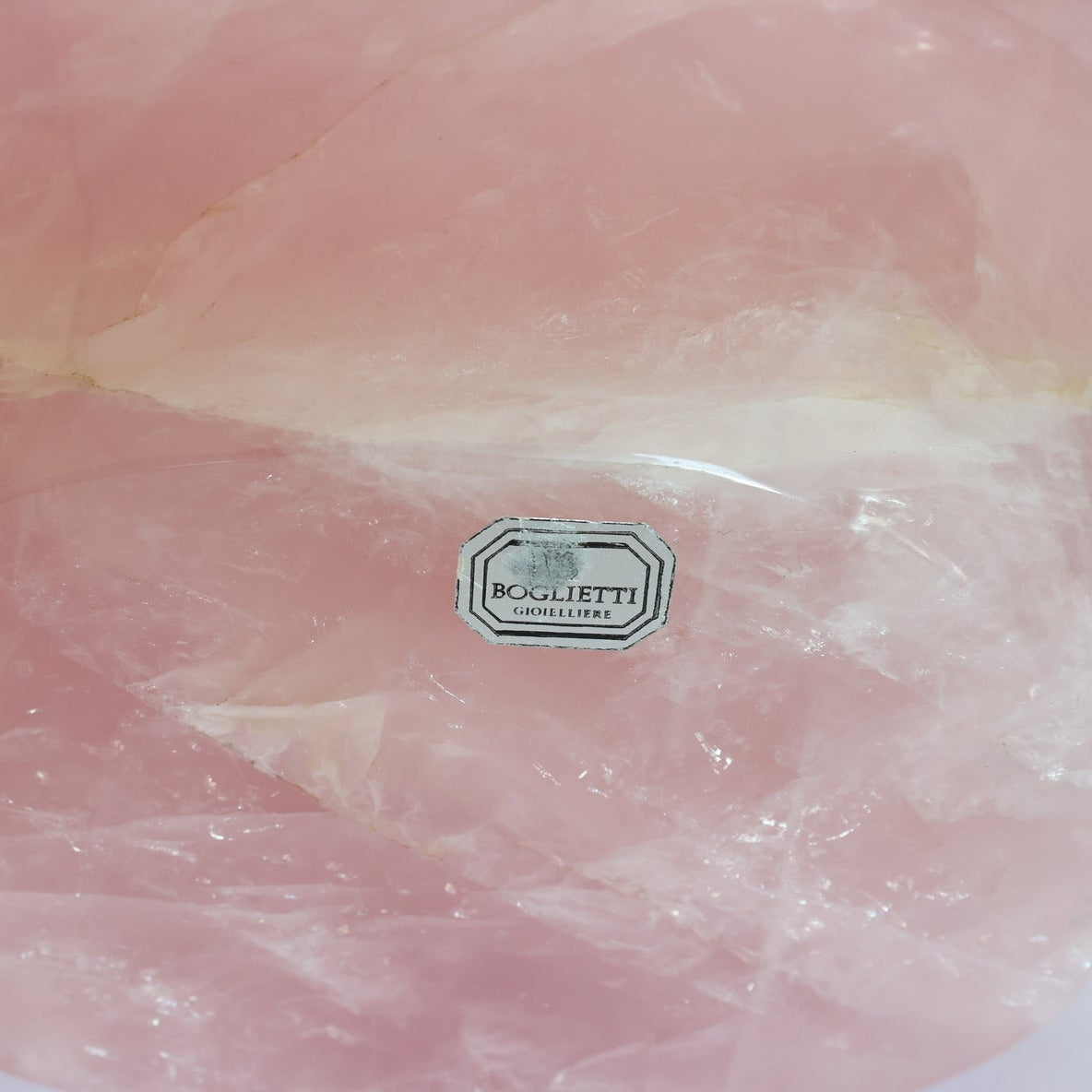 A close-up of the Carved Rose Quartz Bowl by Euro Trash Annie shows its smooth, translucent pink surface with natural white streaks, making it a stunning decorative accent.