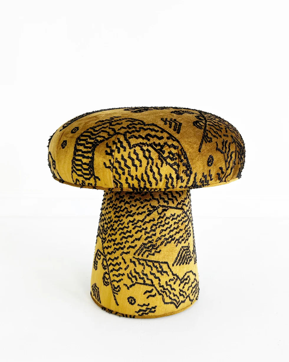 The Forsyth Mushroom Pouf in Dedar 'Tiger Mountain' Jacquard Velvet features a mushroom shape with a wide yellow cushion and conical base, both adorned with intricate black embroidery, creating a striking look against a white background.