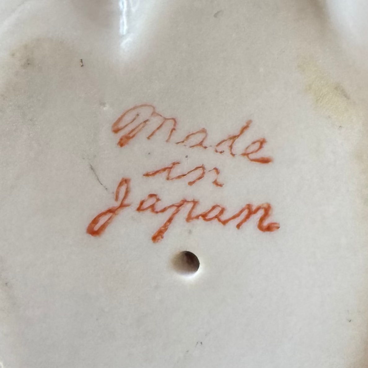 Made in Japan" is handwritten in red on this Euro Trash Annie Vintage Porcelain Hand Ring Holder, featuring a small round hole below the text—a charming decorative accent for your space.