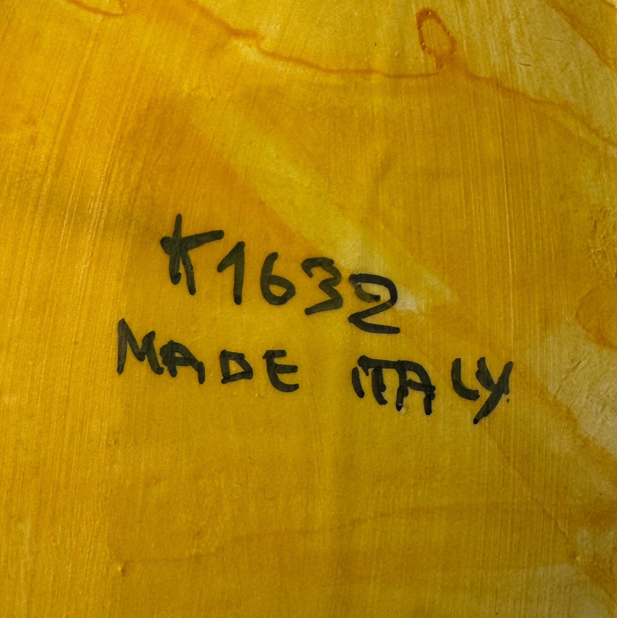Handwritten text "K1632 MADE ITALY" in black ink appears on the textured yellow-orange base of a Vintage Floral Capodimonte Style Porcelain Sculpture by Euro Trash.