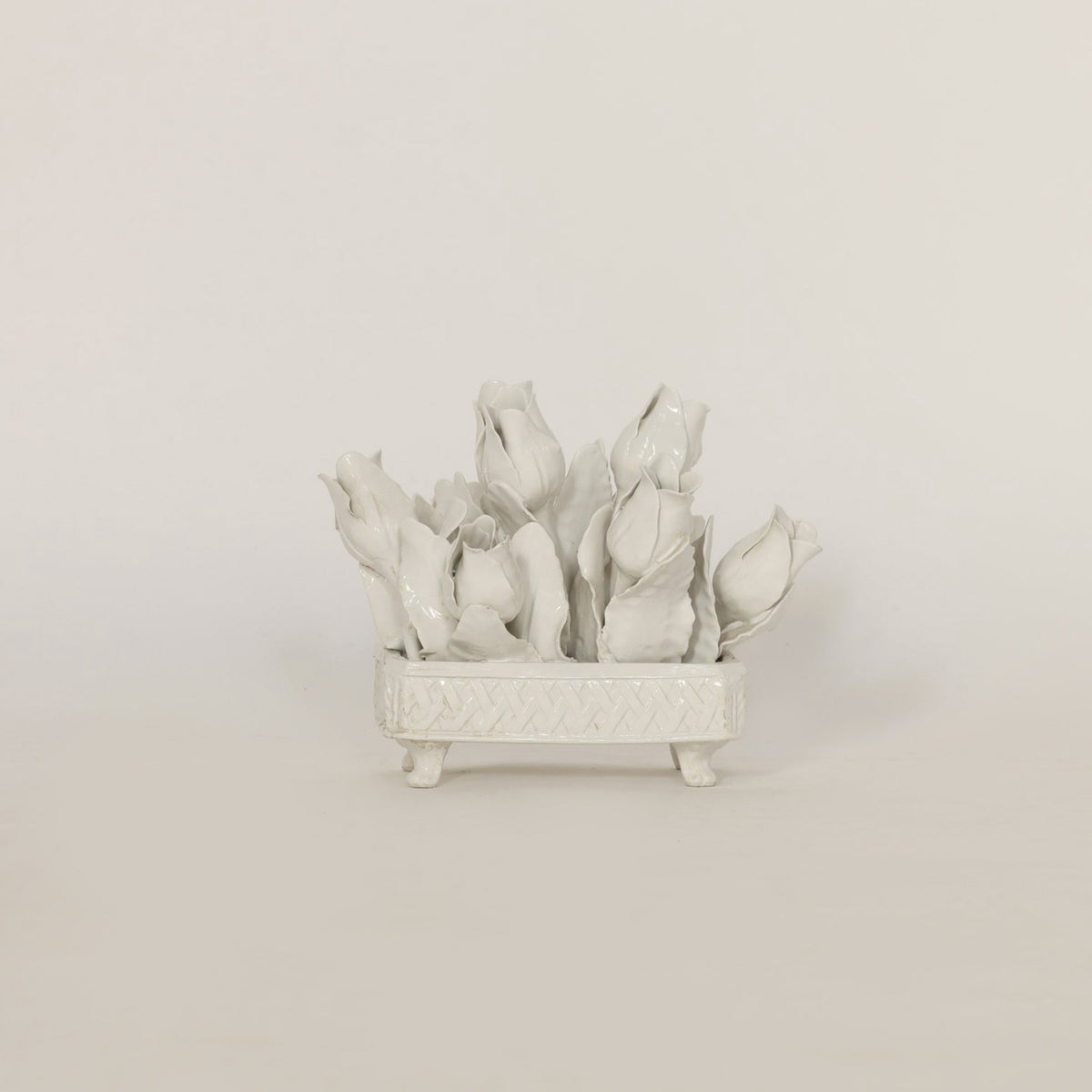 White ceramic flower arrangement on a light gray background