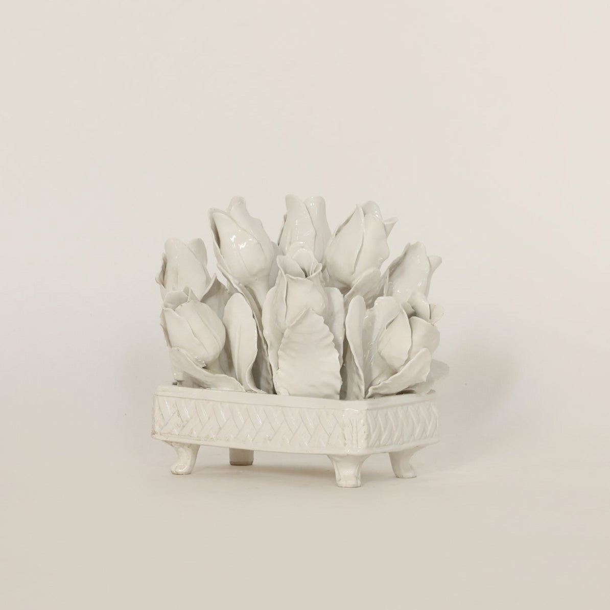 White ceramic flowerpot with tulip design on a beige background