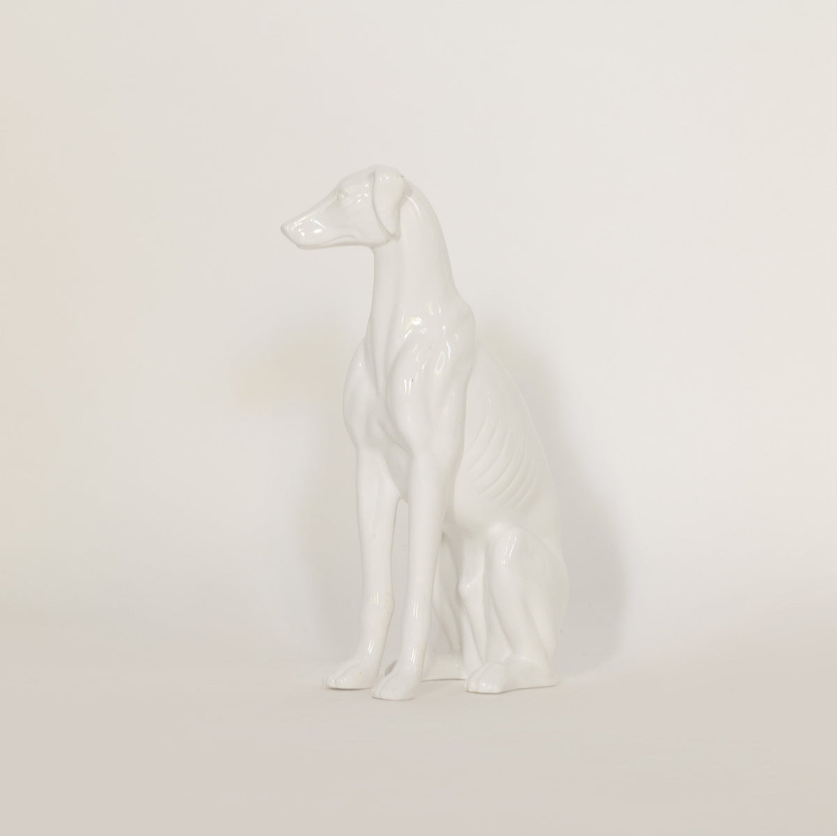 White ceramic dog figurine on a light beige background