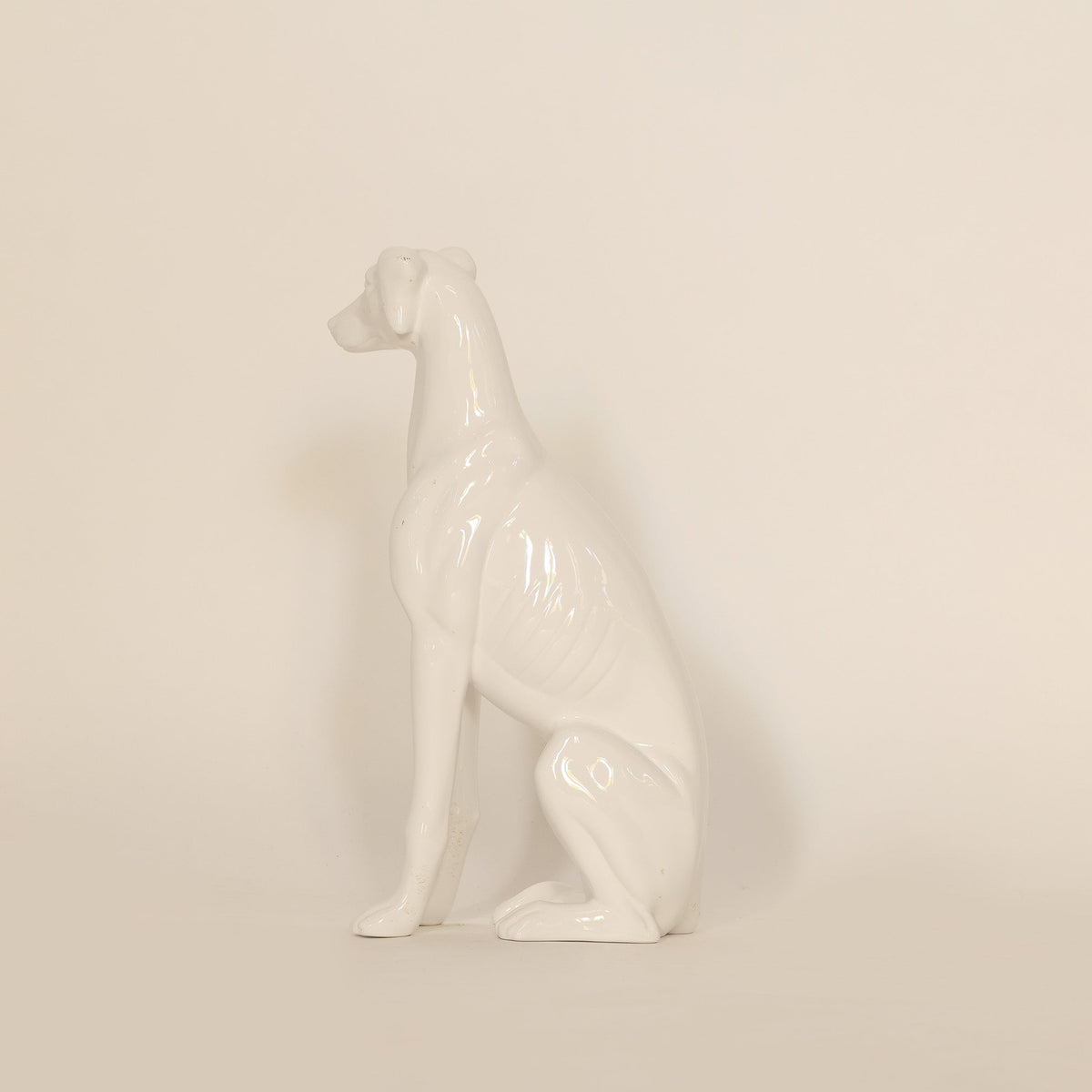 White ceramic dog figurine on a beige background