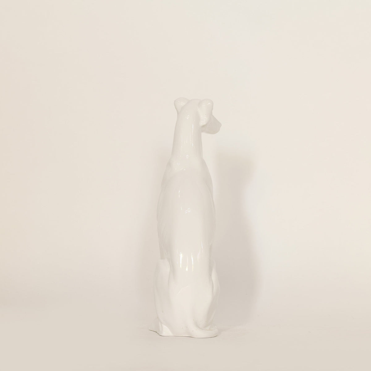 White ceramic dog figurine on a beige background
