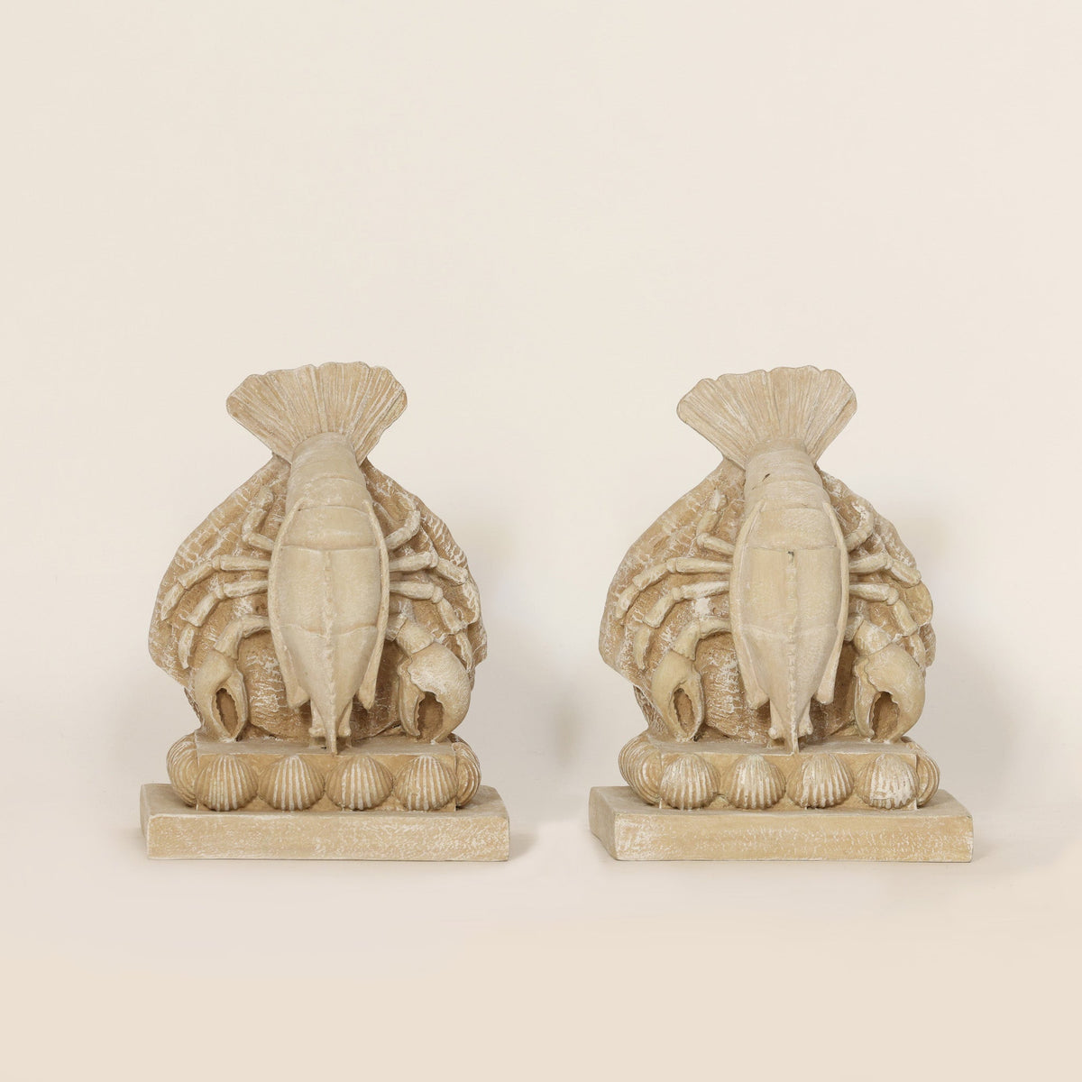 Pair of Coastal Lobster Sculptural Bookends on beige background.
