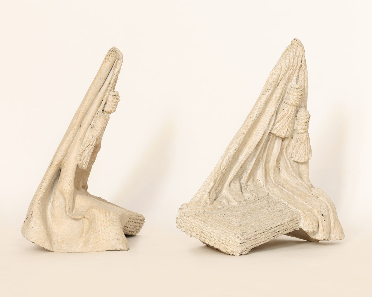 Sculptural pair of wall pieces on a beige background