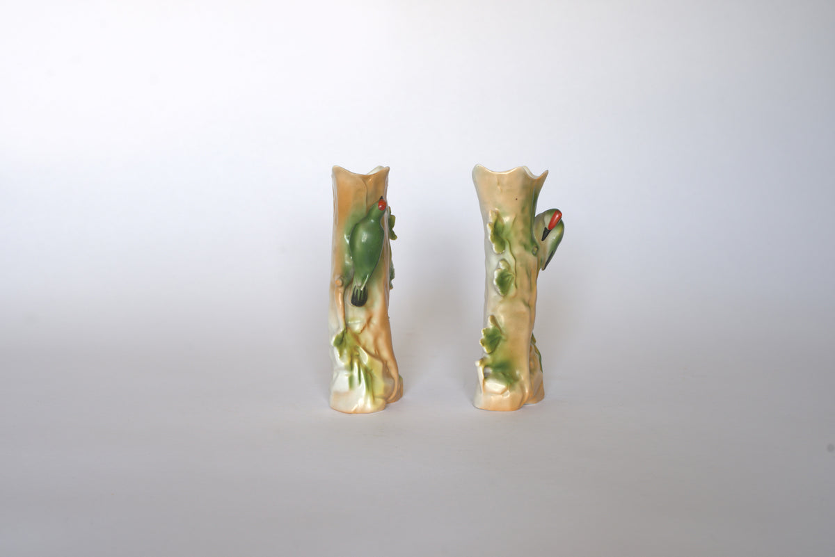 The Pair of Vintage Ceramic Hand-Painted Bird Vases by Euro Trash, shaped like tree trunks with charming bird designs, are displayed side by side on a light background—ideal for adding a cottage aesthetic to any space.