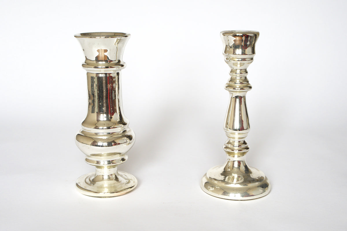 The Euro Trash Pair of Vintage Mercury Glass Candleholders, featuring different designs and heights, is displayed on a white background. The left holder is wider and shorter, while the right is taller and slimmer.