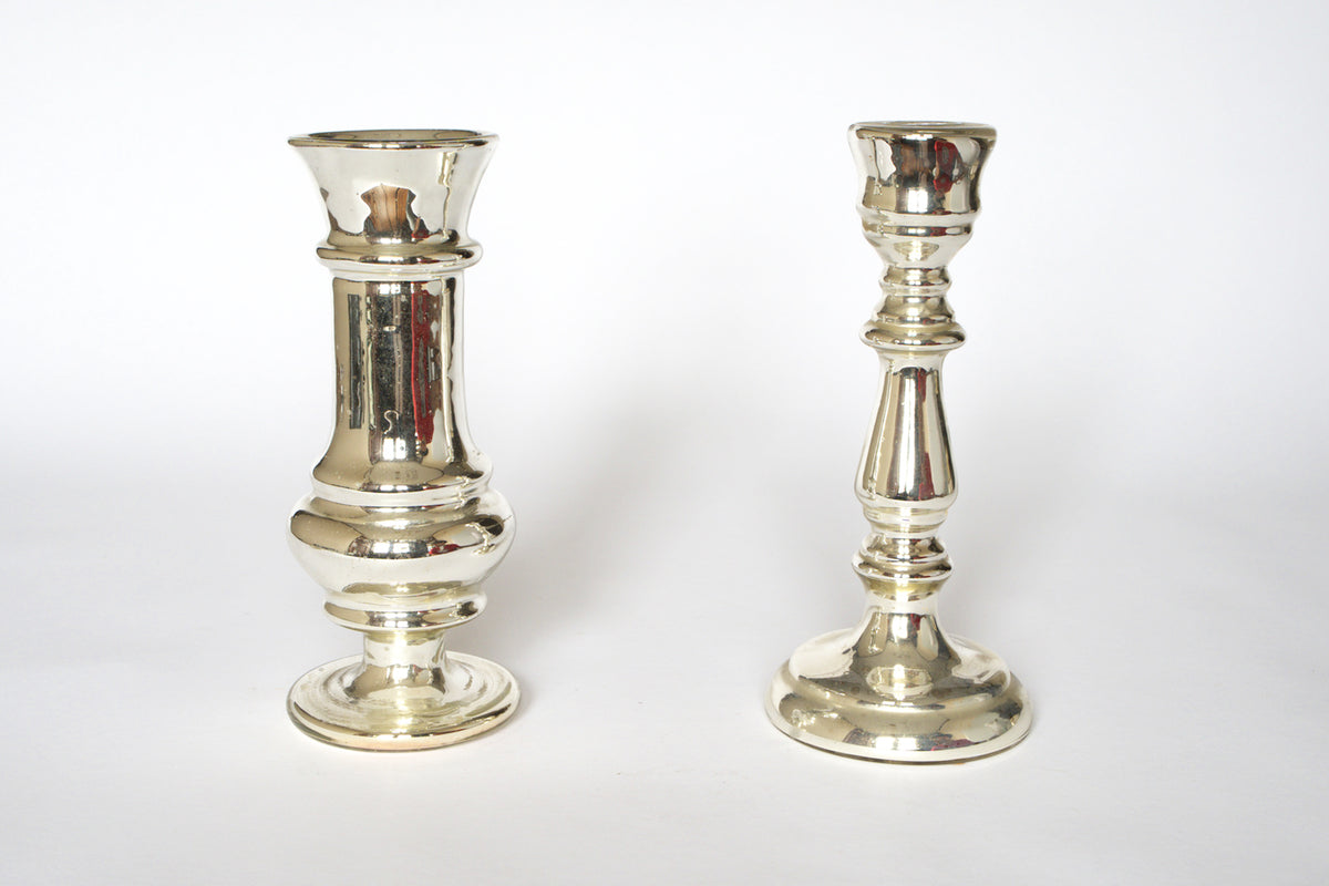 A pair of Euro Trash Vintage Mercury Glass Candleholders, each with a unique design, stand upright on a plain white background.